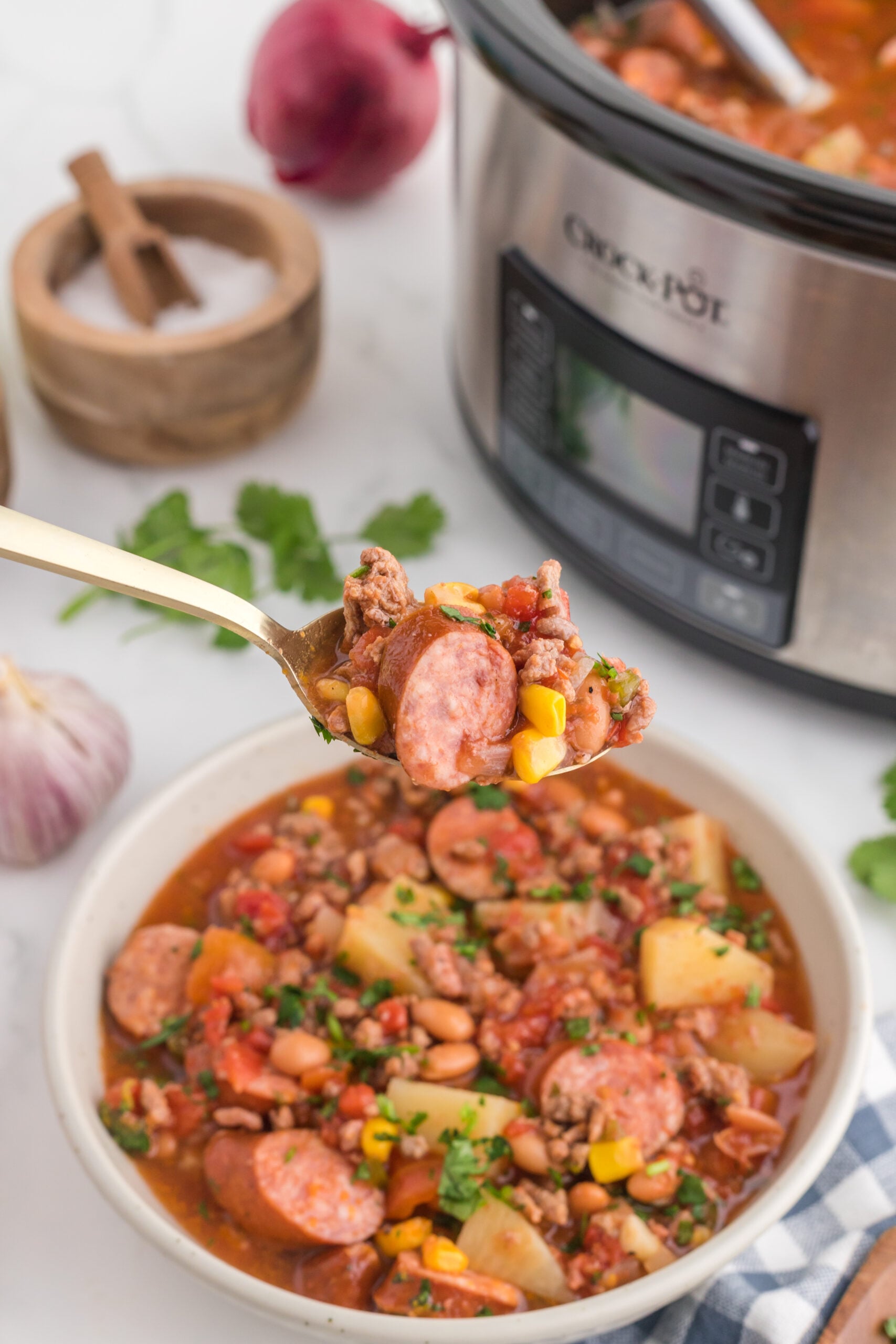 Close up view of a bite of Slow Cooker Texas Cowboy Stew in a silver spoon.