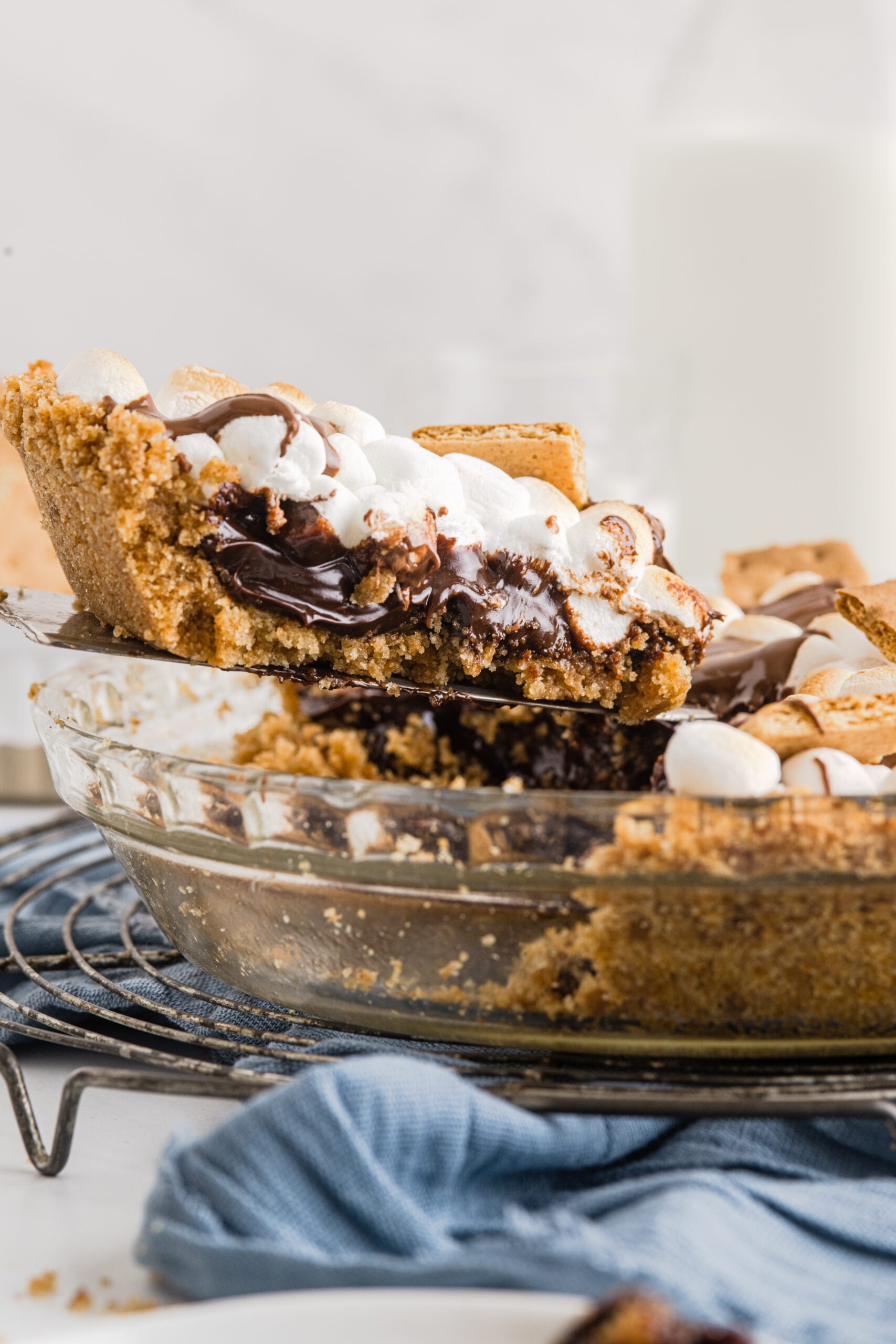 A piece of S'mores Pie being removed from the baking dish with a silver spatula. 