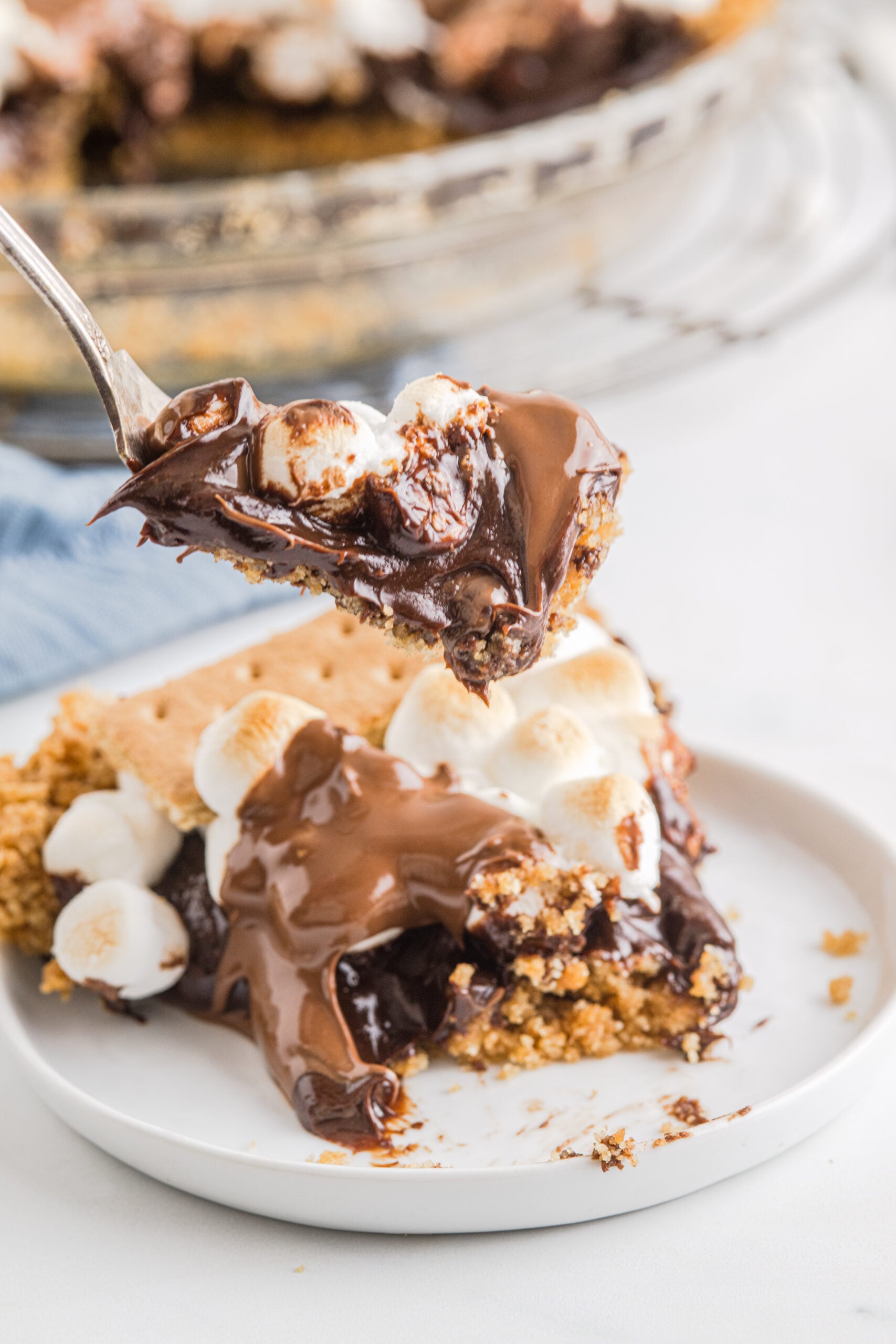 A silver fork removing a bite of S'mores Pie.