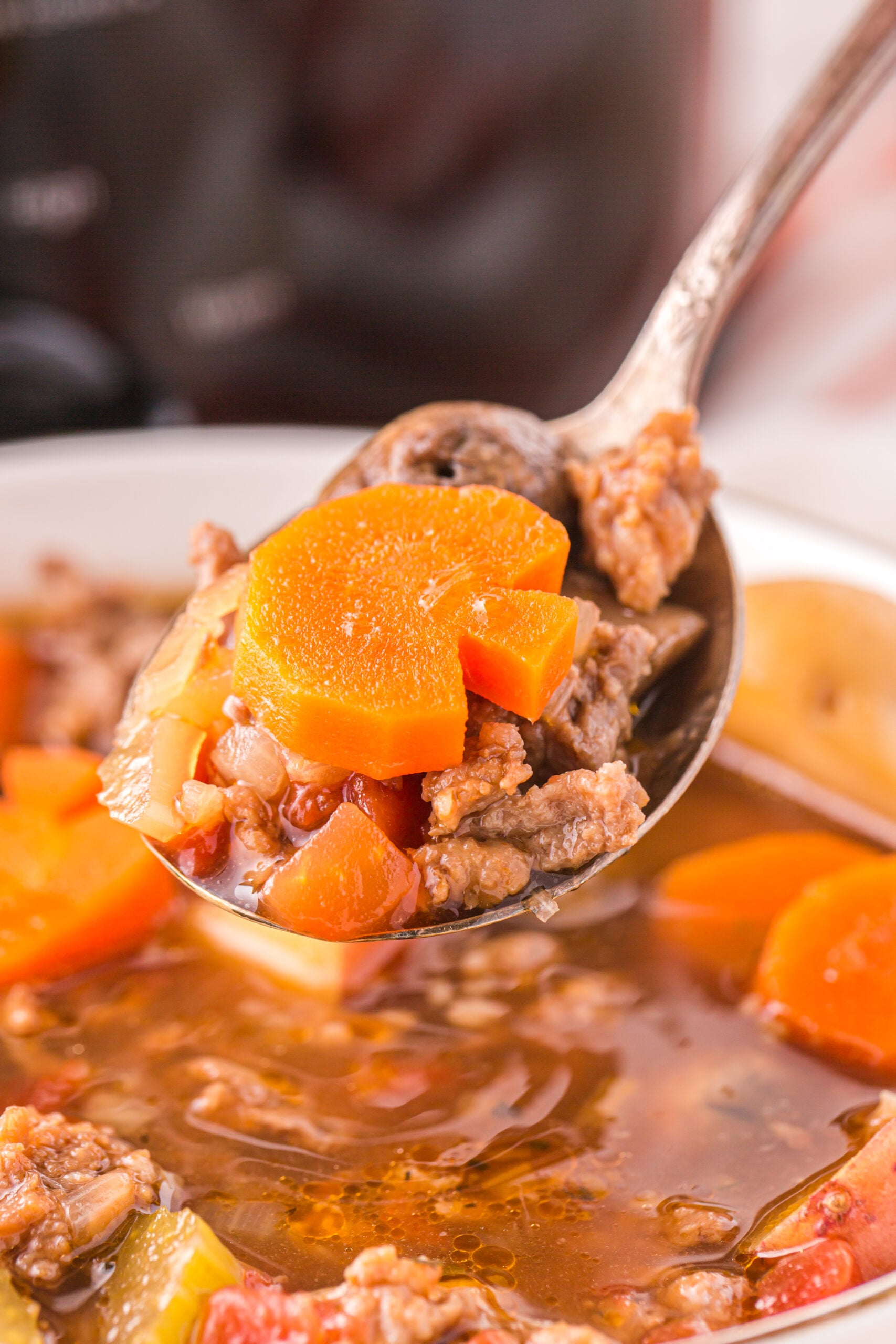 Close up view of a silver spoon removing a bite of Witches Brew Stew.