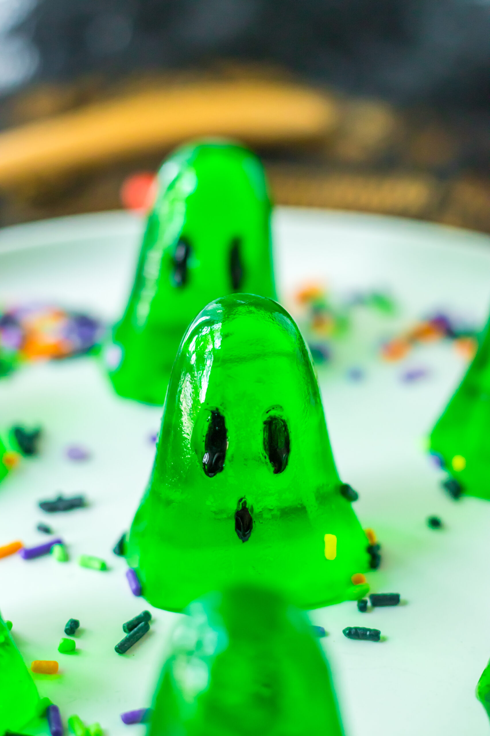 platter with green ghost jello shots on it with a sprinkles on the plate