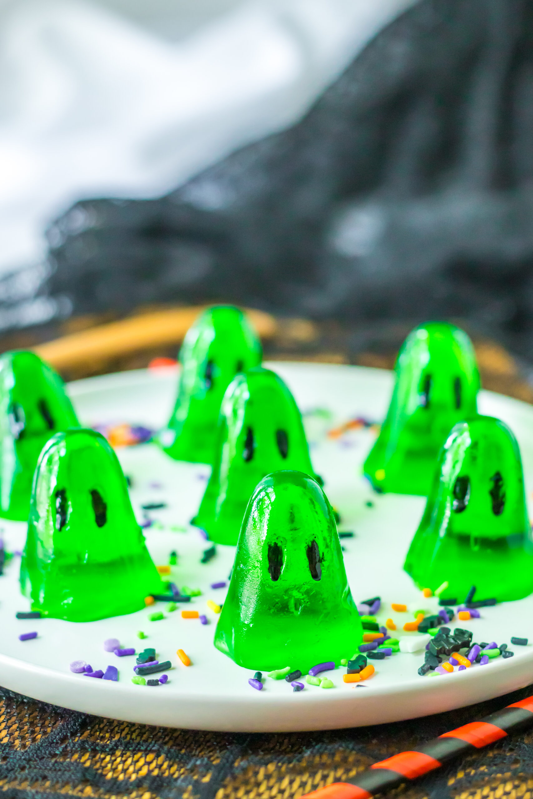 Green shot jello shots on a white plate for halloween