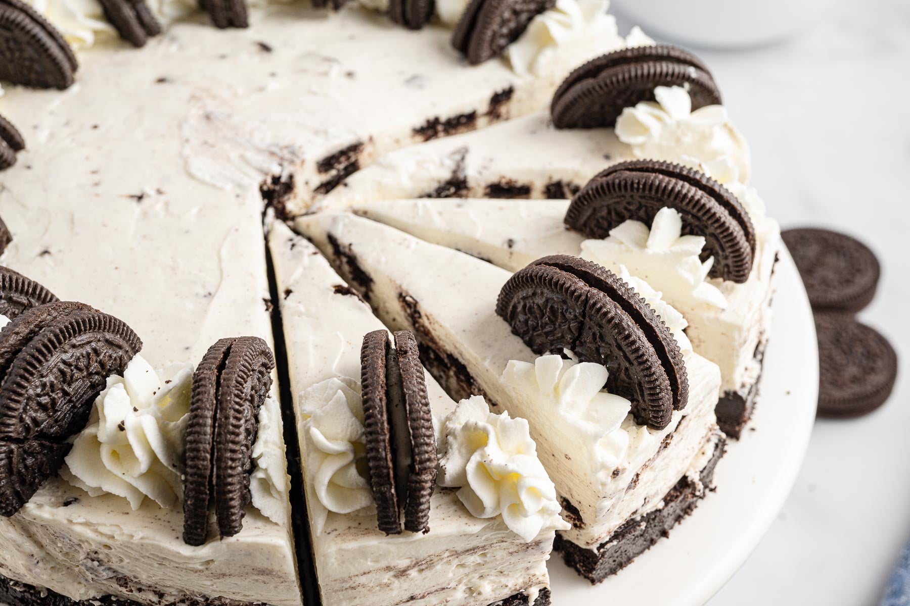 No Bake Oreo Cheesecake side view with a bunch of pieces slice