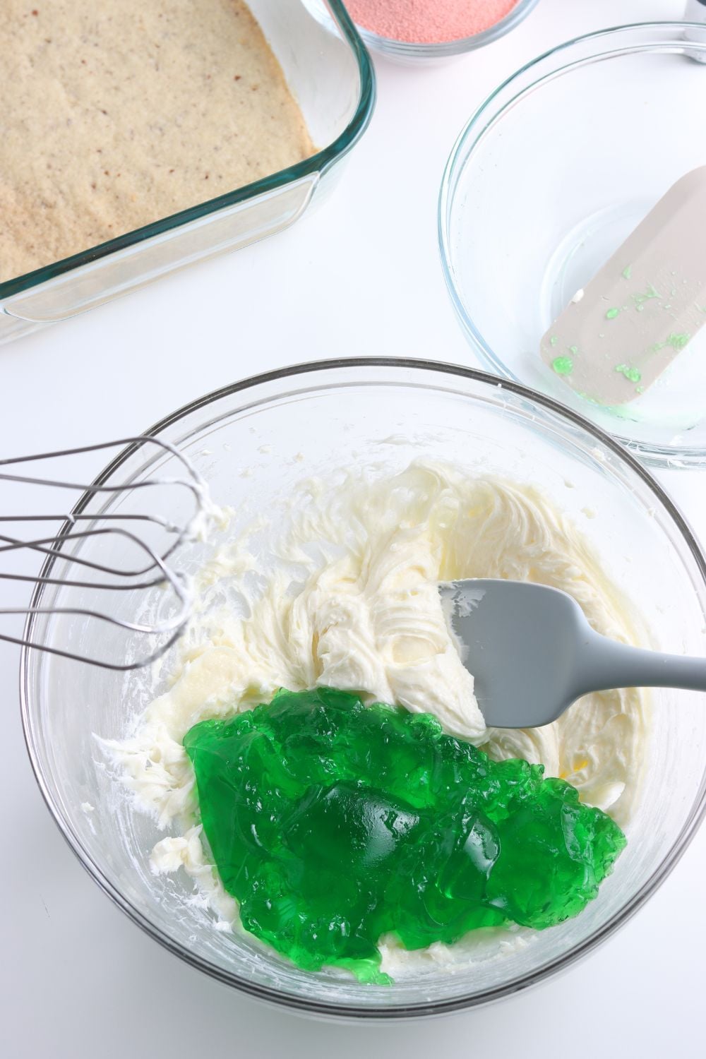 green jello and whipped cream in a glass bowl