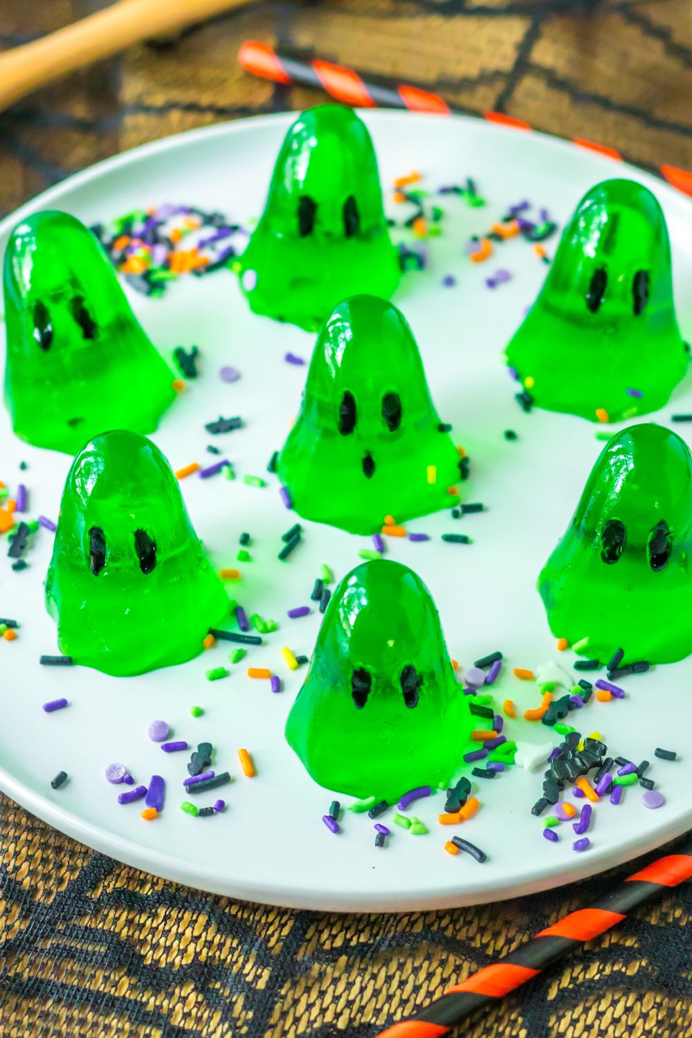 ghost shaped jello shots sitting on table on a plate with sprinkles