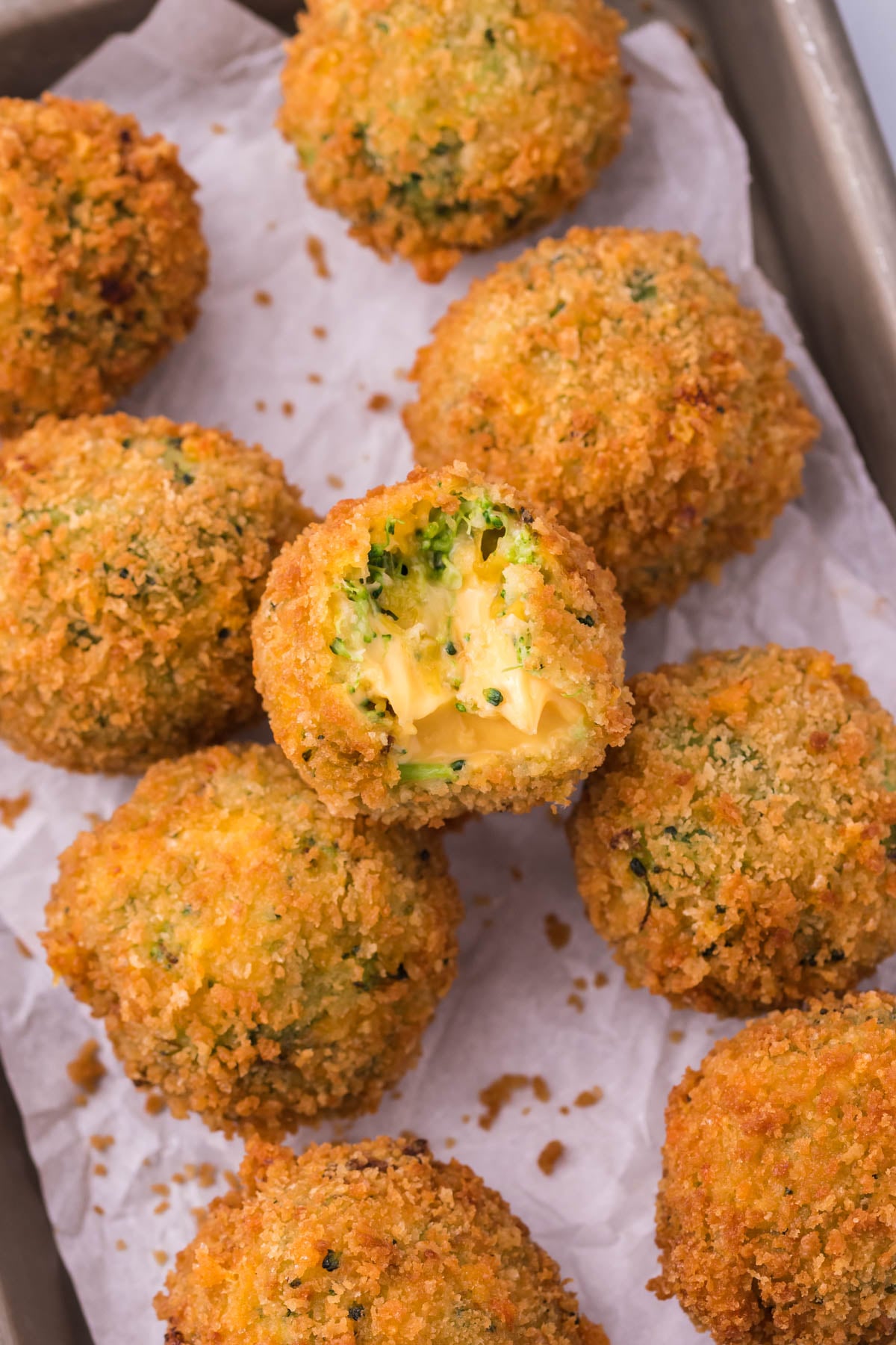 Fried Broccoli Bites sitting in rows on a silver baking sheet