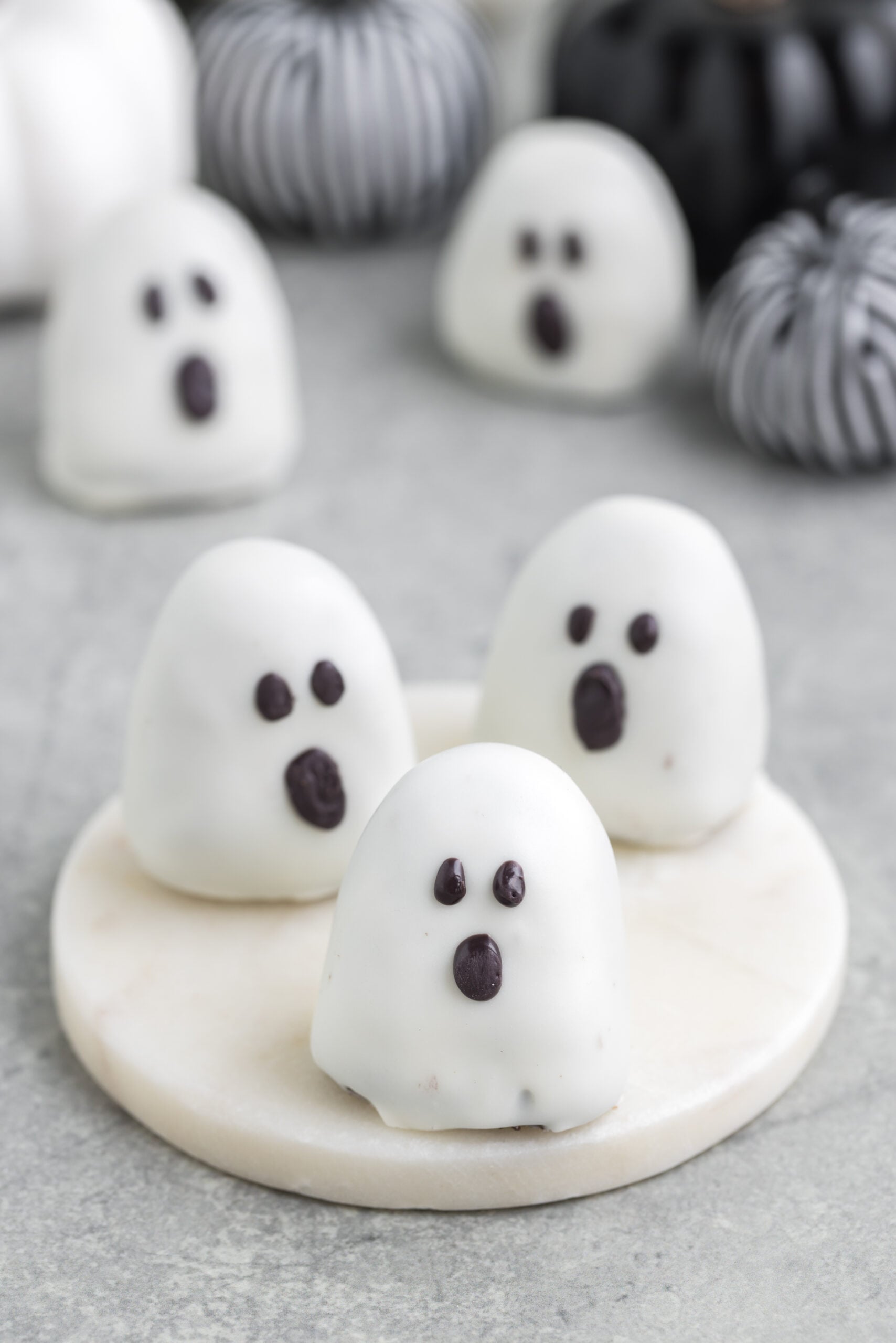 spooky Oreo truffles on table with fabric pumpkins behind them