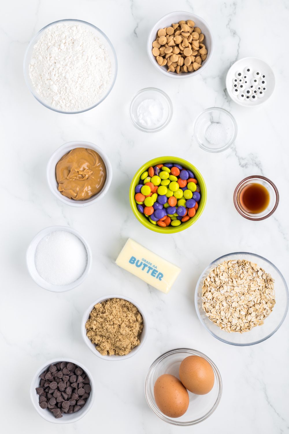 ingredients for monster cookie bars on table in glass bowls