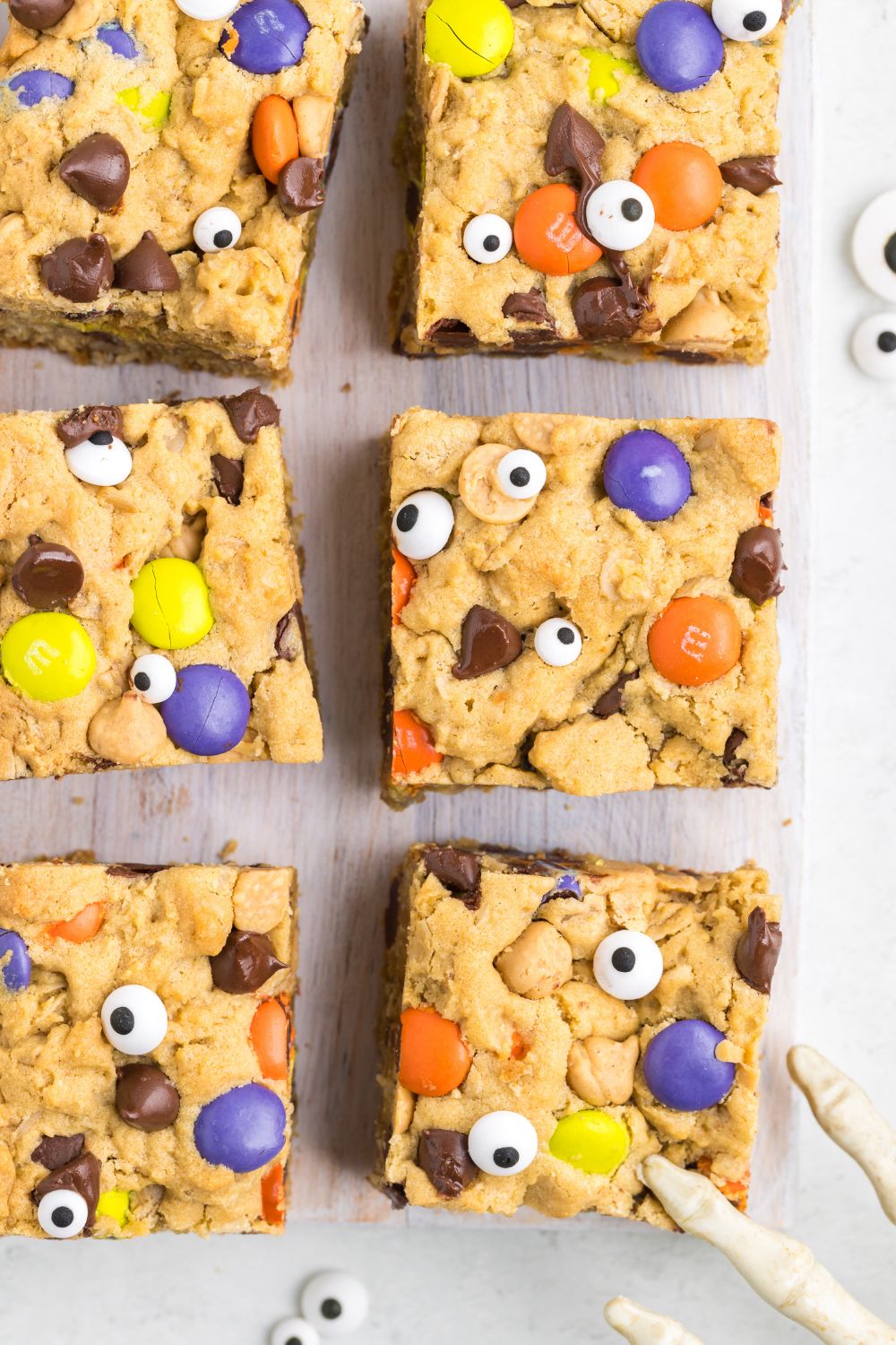 Halloween Monster Cookie Bars set out on table with halloween decor around them