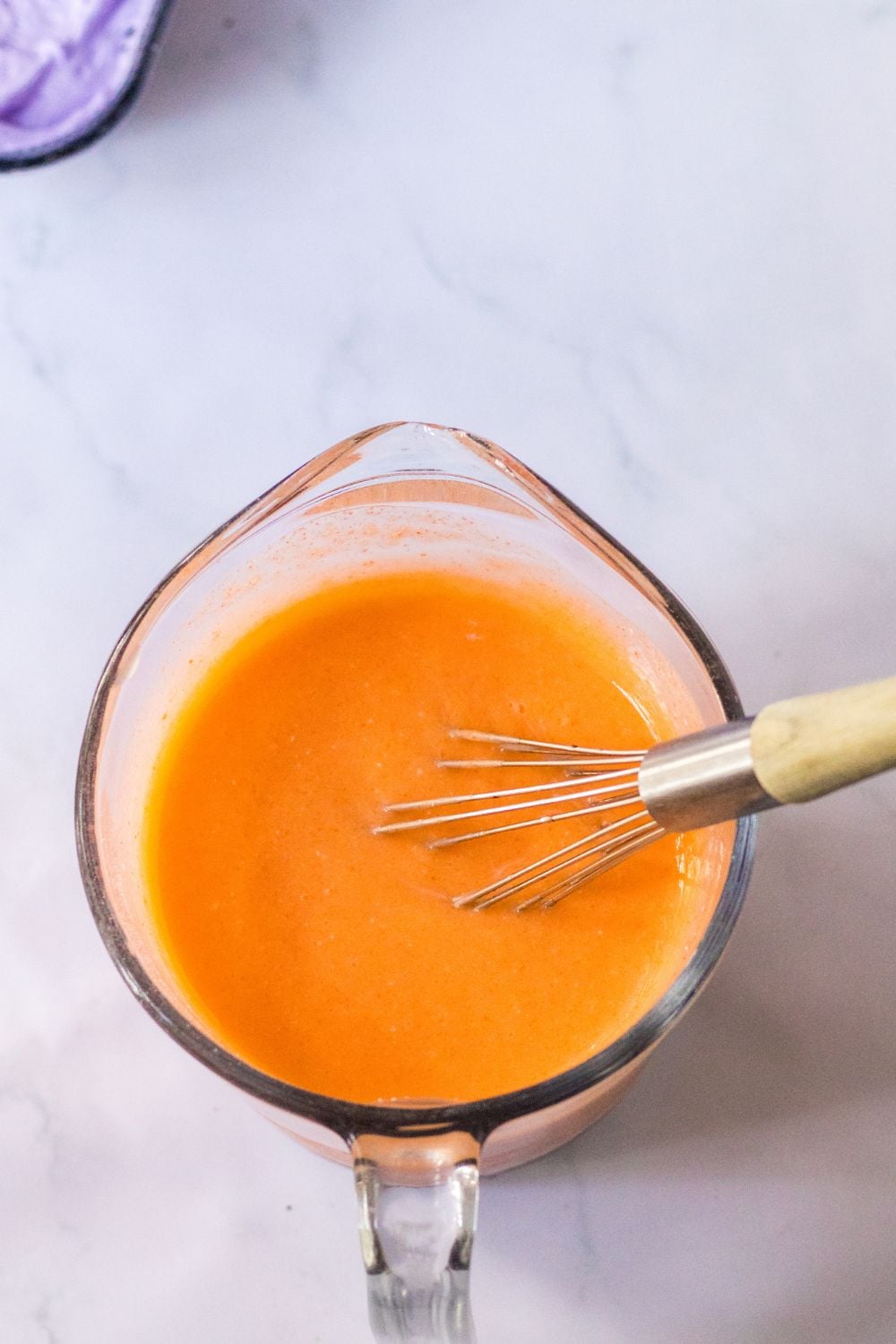 orange jello mixture in measuring cup 