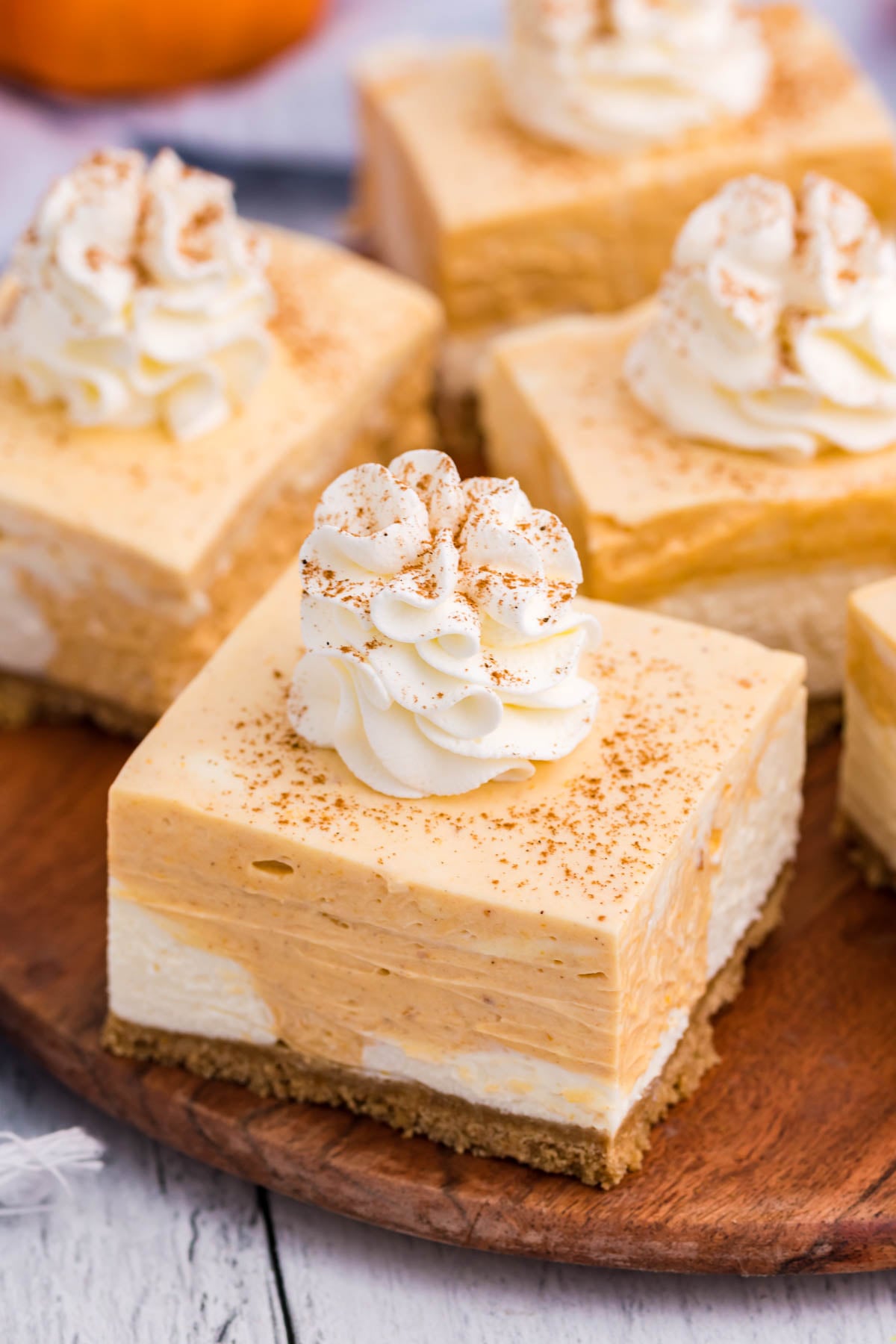 No Bake Pumpkin Cheesecake Bars sliced on a wood serving platter