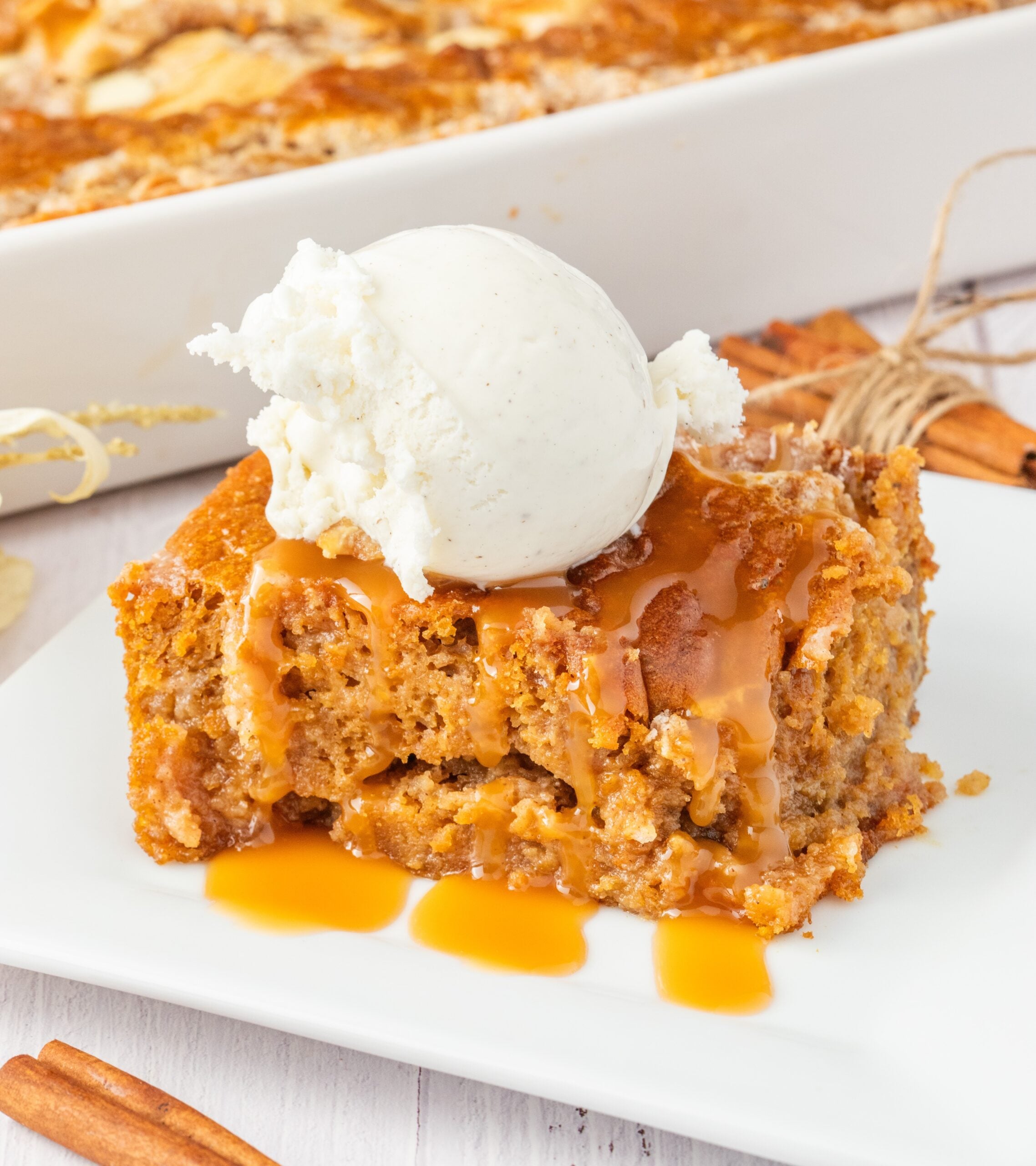 sliced earthquake cake on plate drizzled with caramel and a scoop of vanilla ice cream