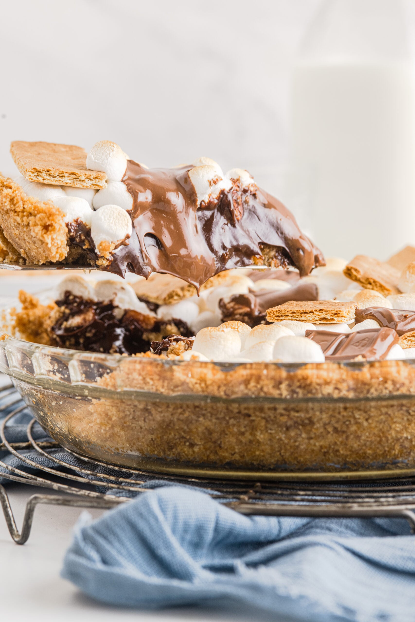 S'mores Pie in a glass baking dish with a slice being lifted out 