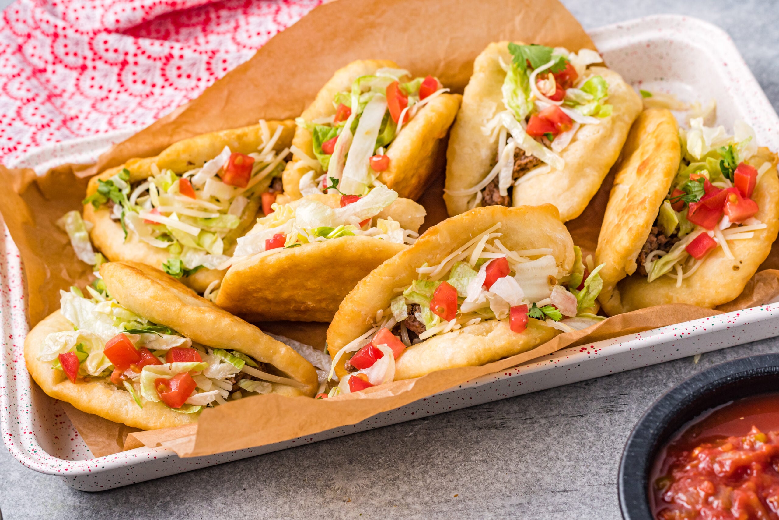 View of Taco Bell Chalupas in a serving tray lined with parchment paper.