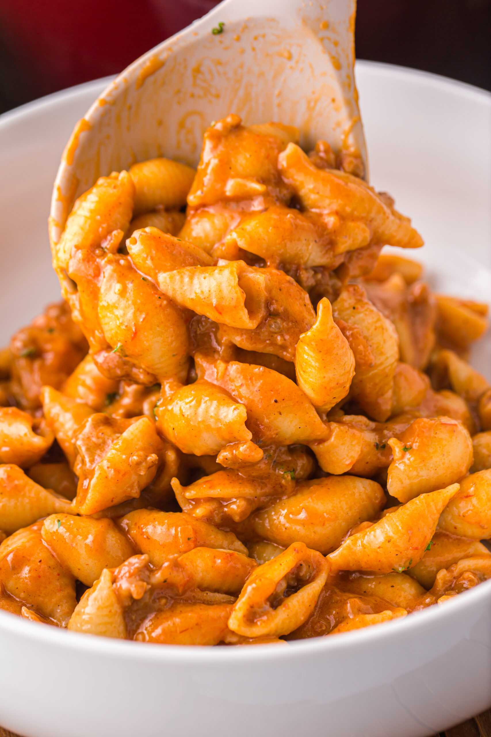 a large white spoon scooping the taco pasta into a white bowl