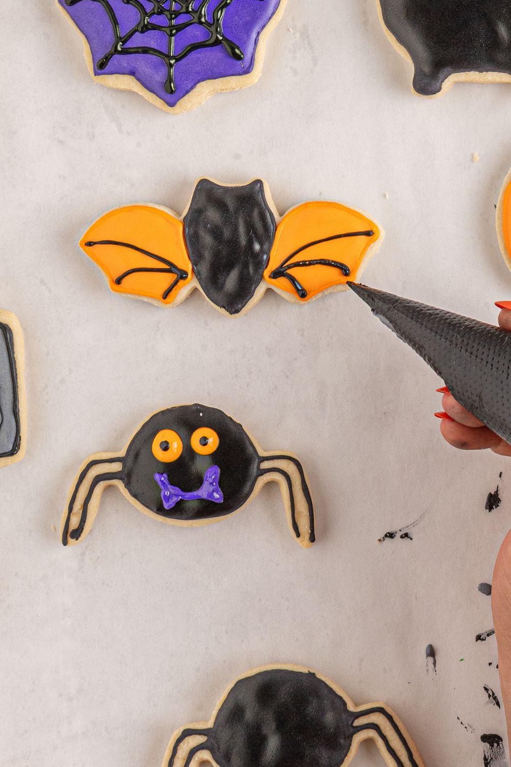 adding lines to a bat cookie with royal icing 