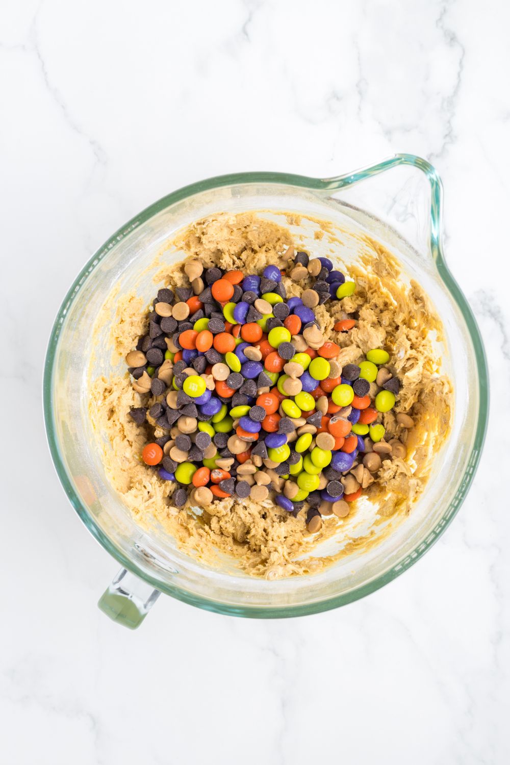 mixing cup with cookie dough and m&ms in it