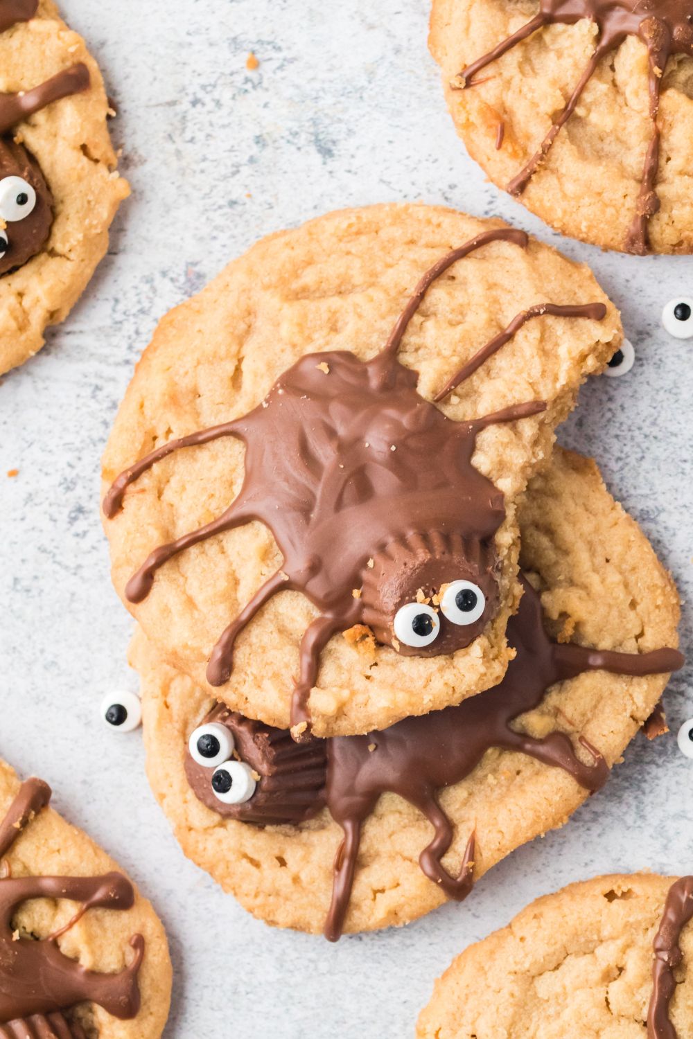 overhead shot of spider cookies on table with one that has a bite taken out