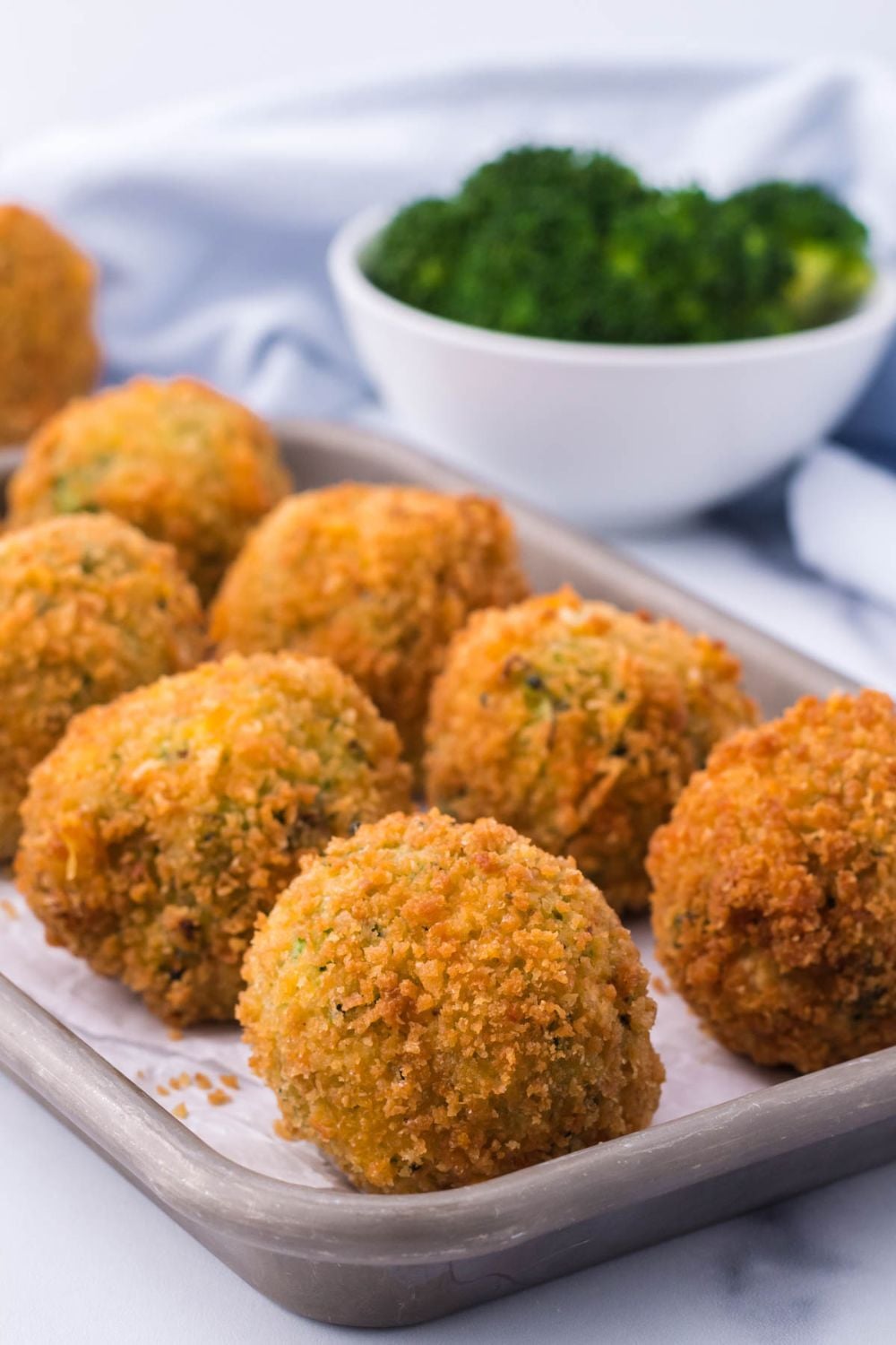 Fried Broccoli Bites sitting in rows on a glass platter
