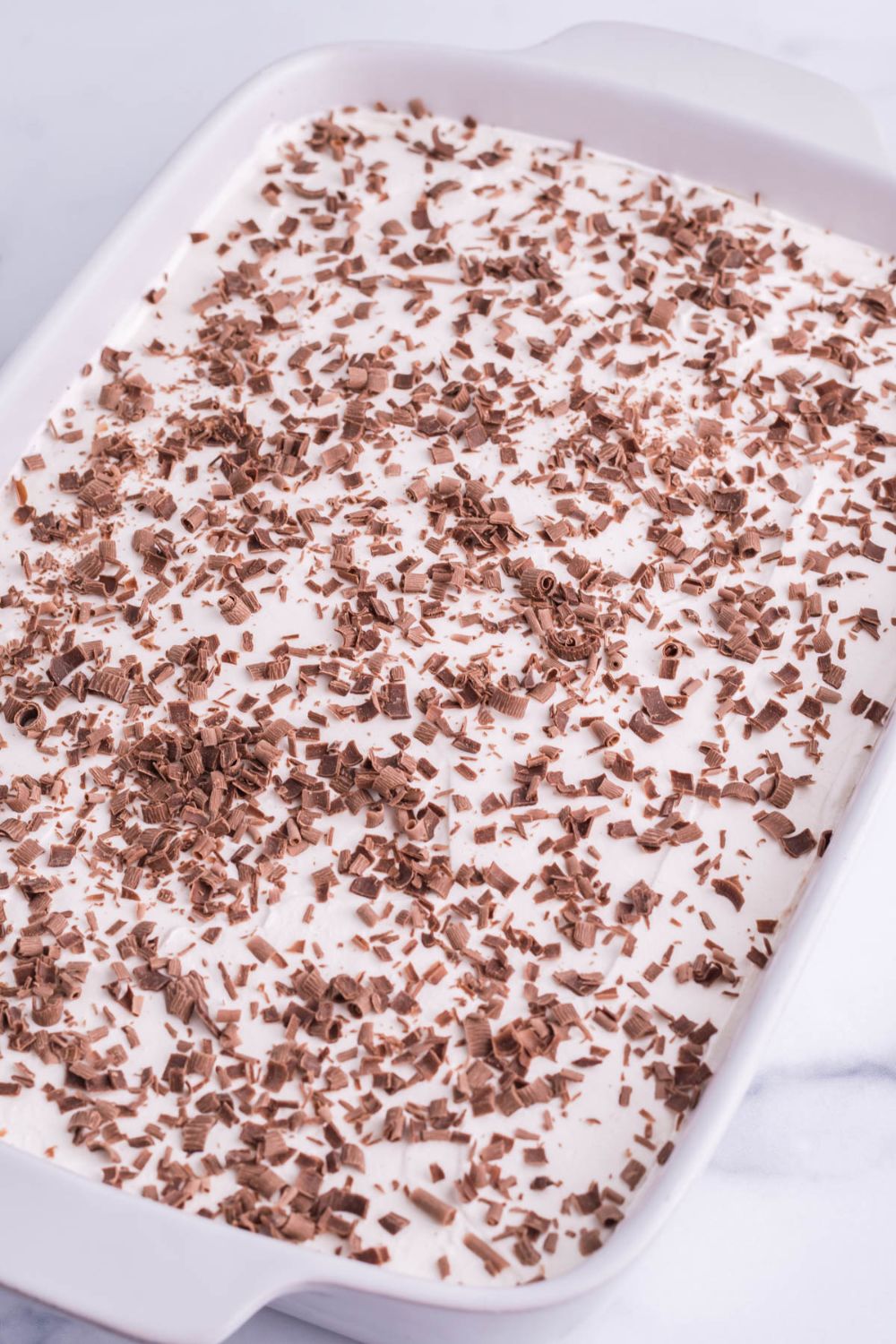 side view of brownies topped with whipped cream and chocolate shavings