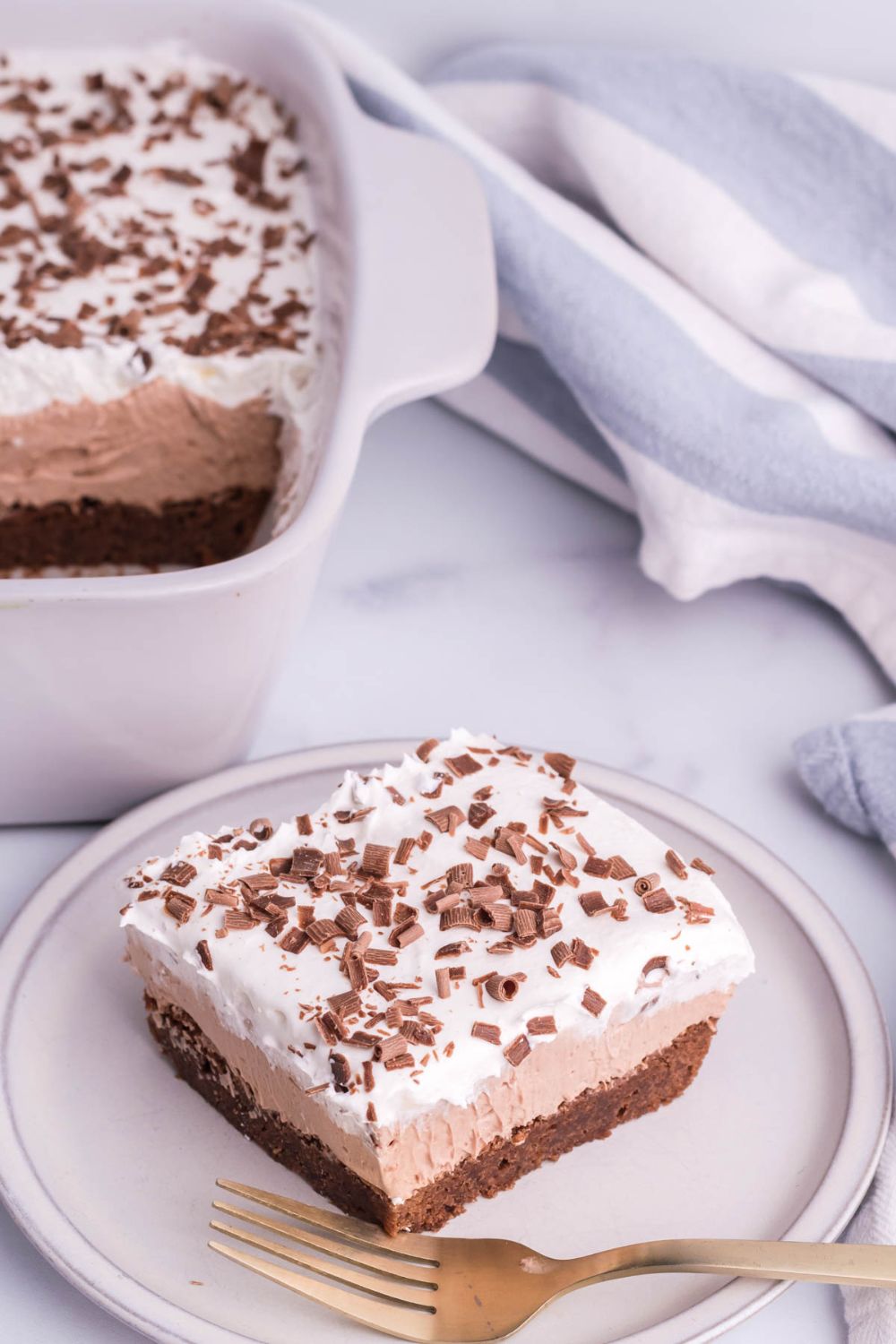 French Silk Brownie in pan and then a sliced brownie on plate on counter 