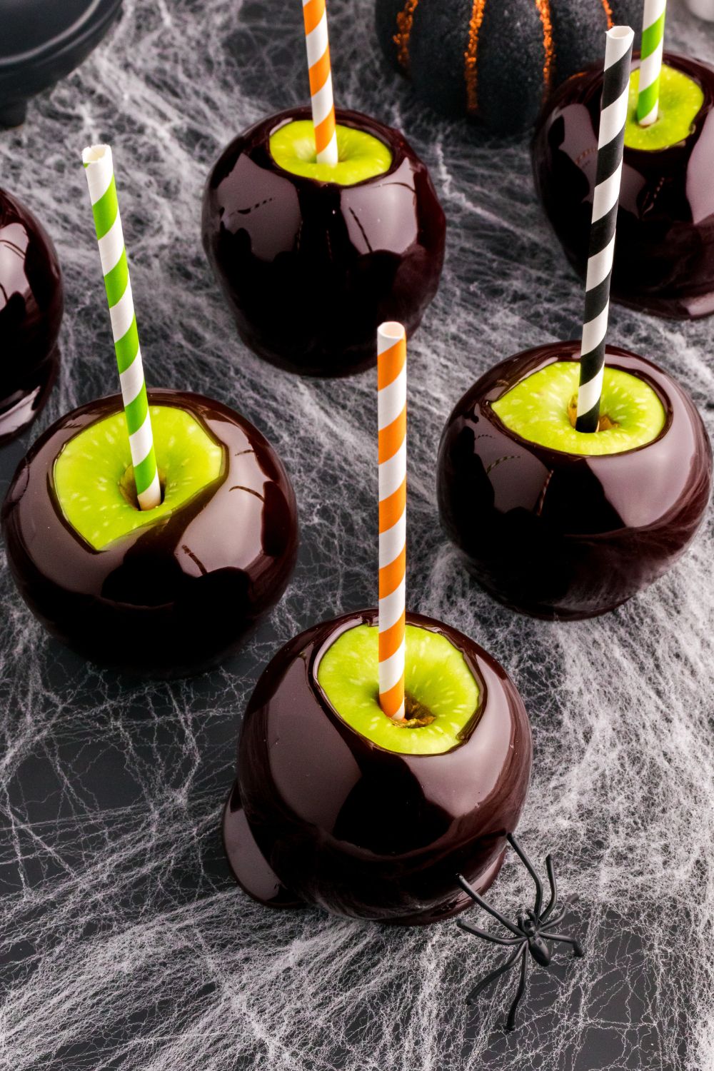 black candy apples on a halloween decorated table
