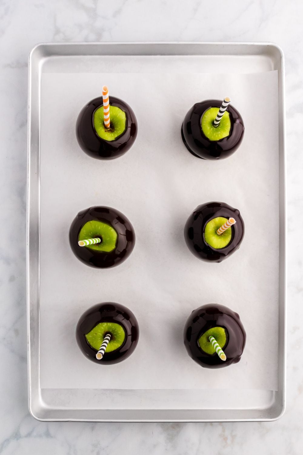 Black Candy Apples on a prepared cookie sheet