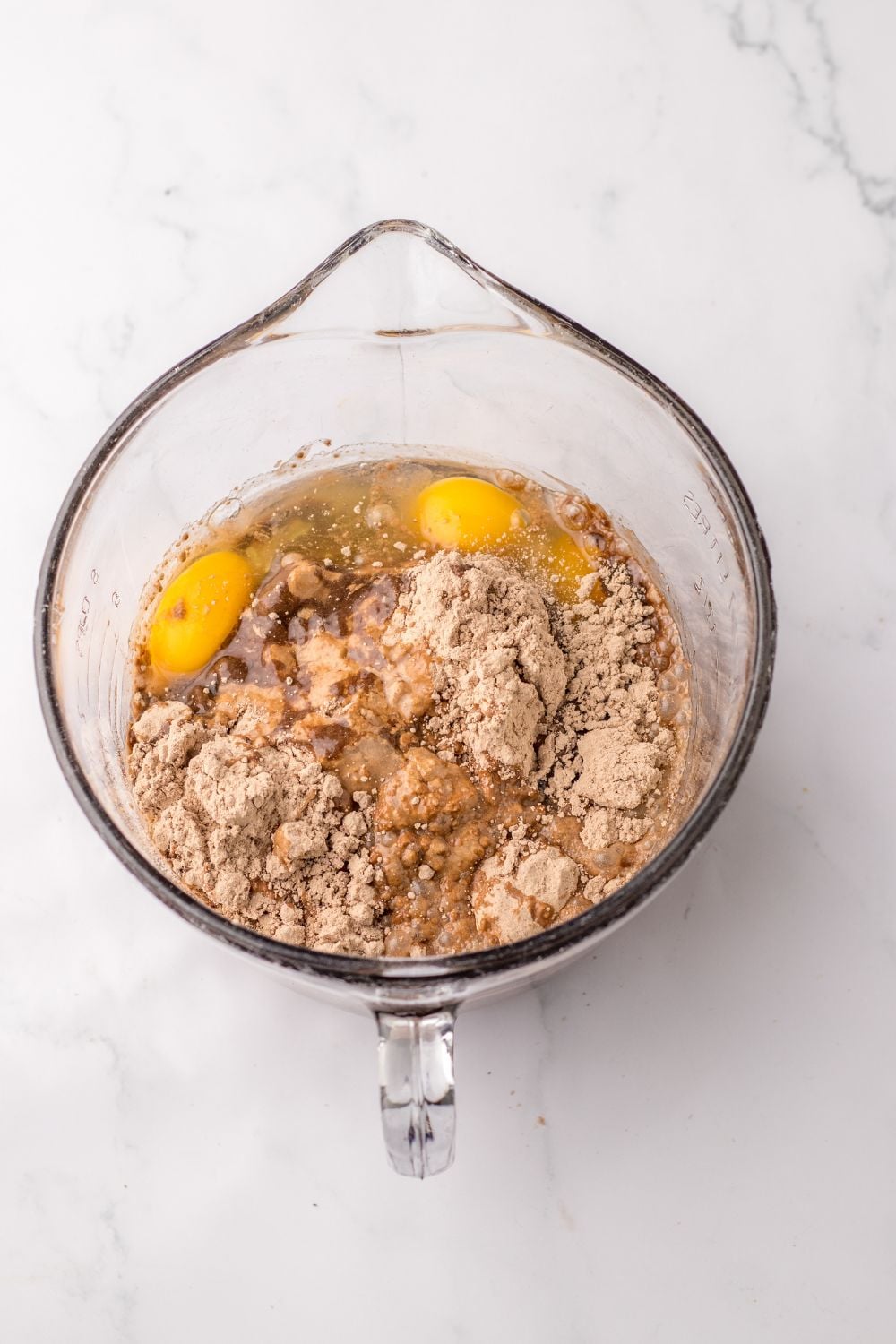 chocolate cake mix with ingredients in a measuring cup on table