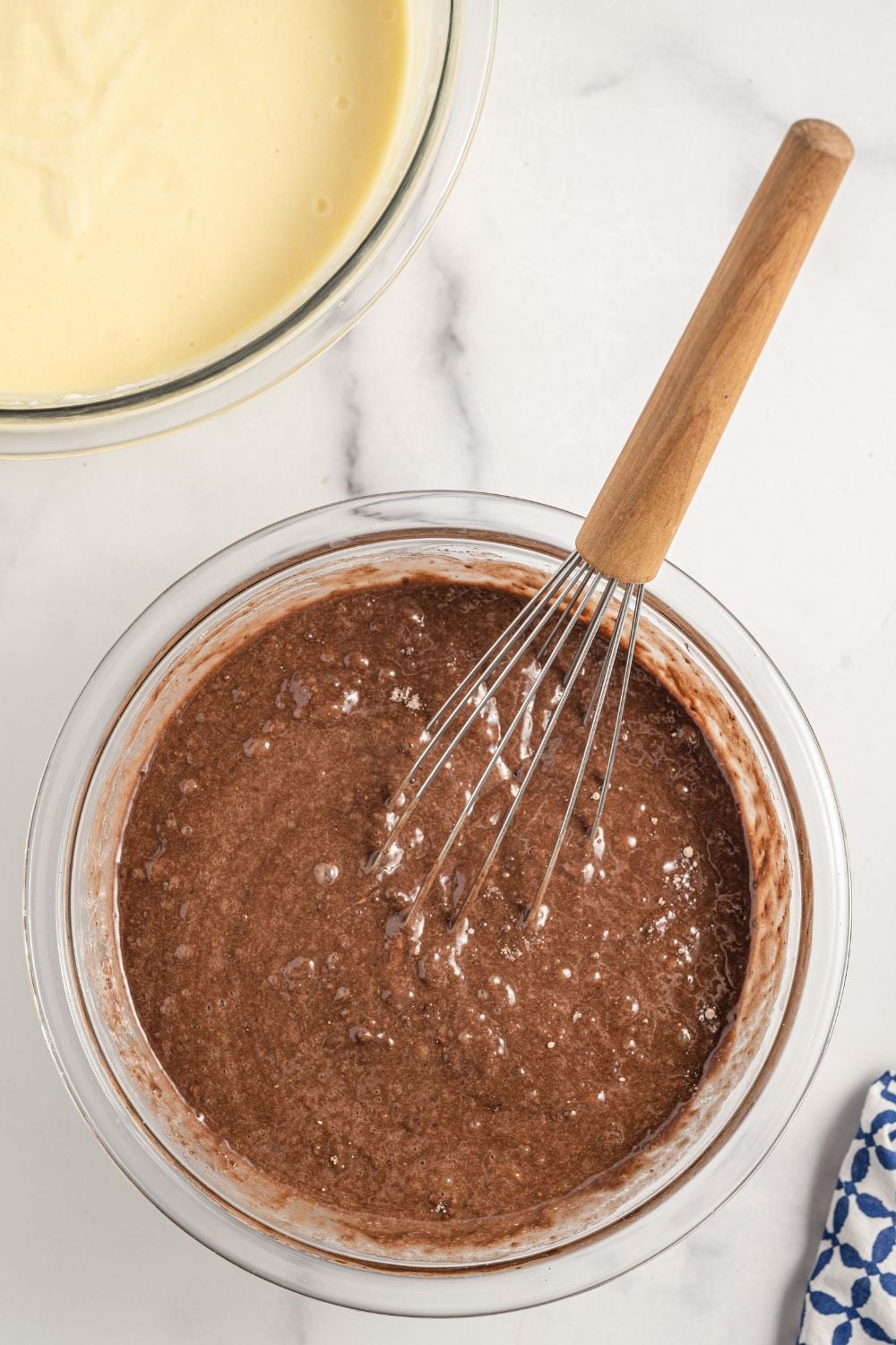 chocolate cake mix in a glass bowl with whisk in it 
