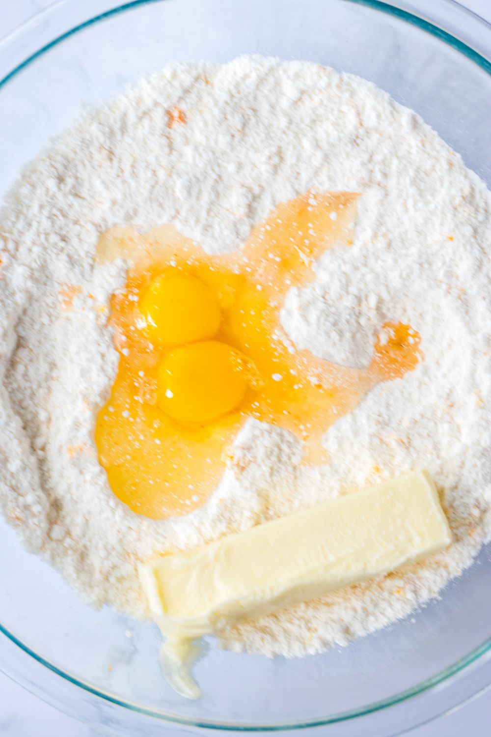 butter and egg mixture on top of cake mix batter 