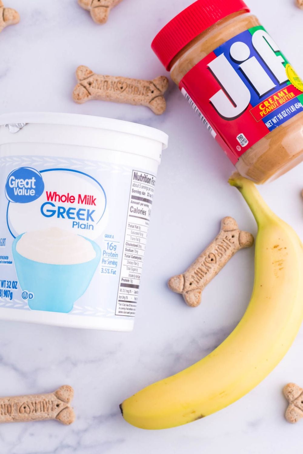 ingredients for making a peanut butter popsicle for dogs on a white table