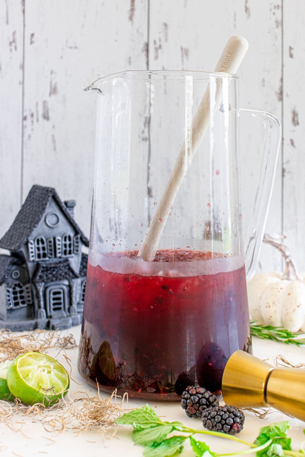 margarita in a stirring glass with garnishes aroud it