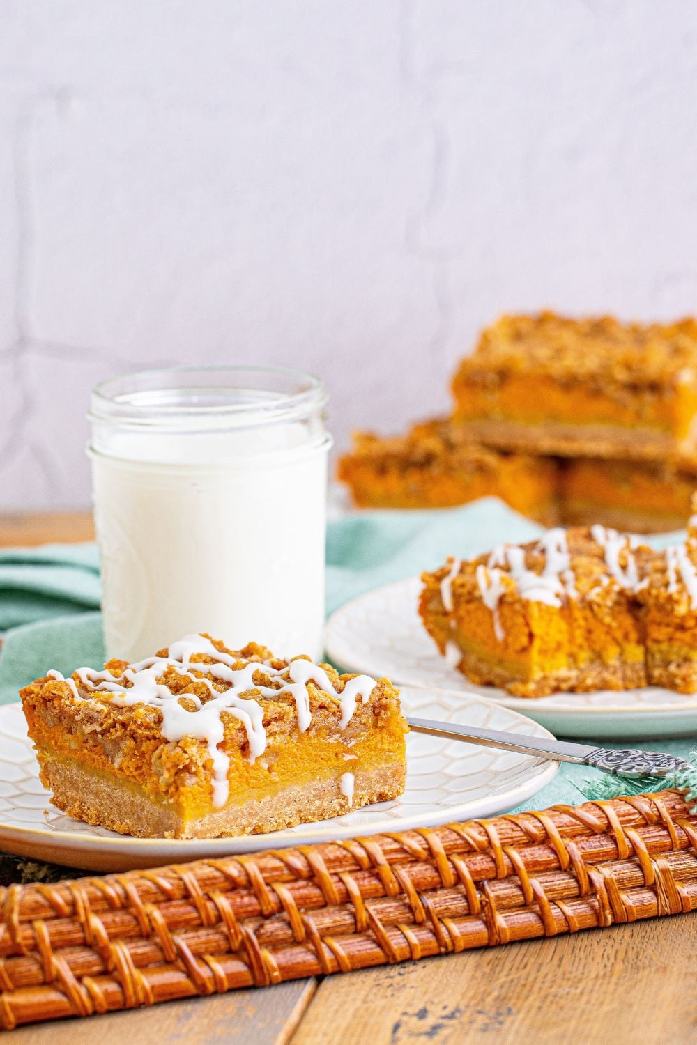 streusel pumpkin bars on a serving tray with a glass of milk behind it