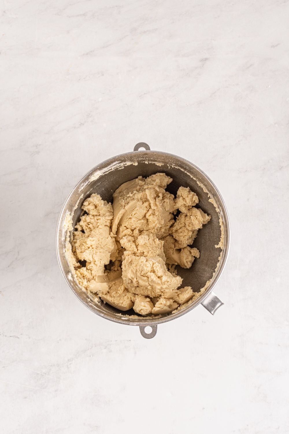 overhead shot of sugar cookie dough formed in a bowl on table 