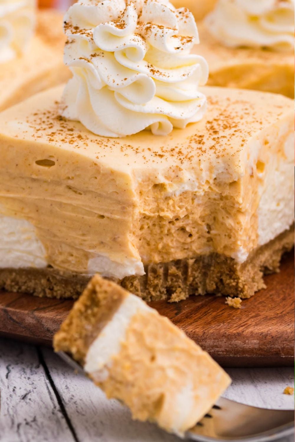 fall cheescake bar with a slice taken out on fork in front of the bar