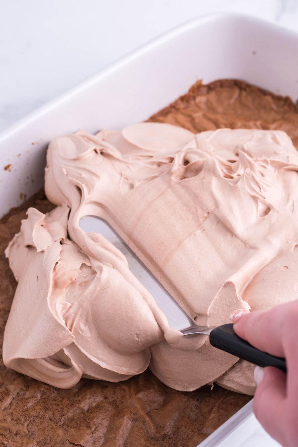 spreading french silk pie filling over the top of the brownies 