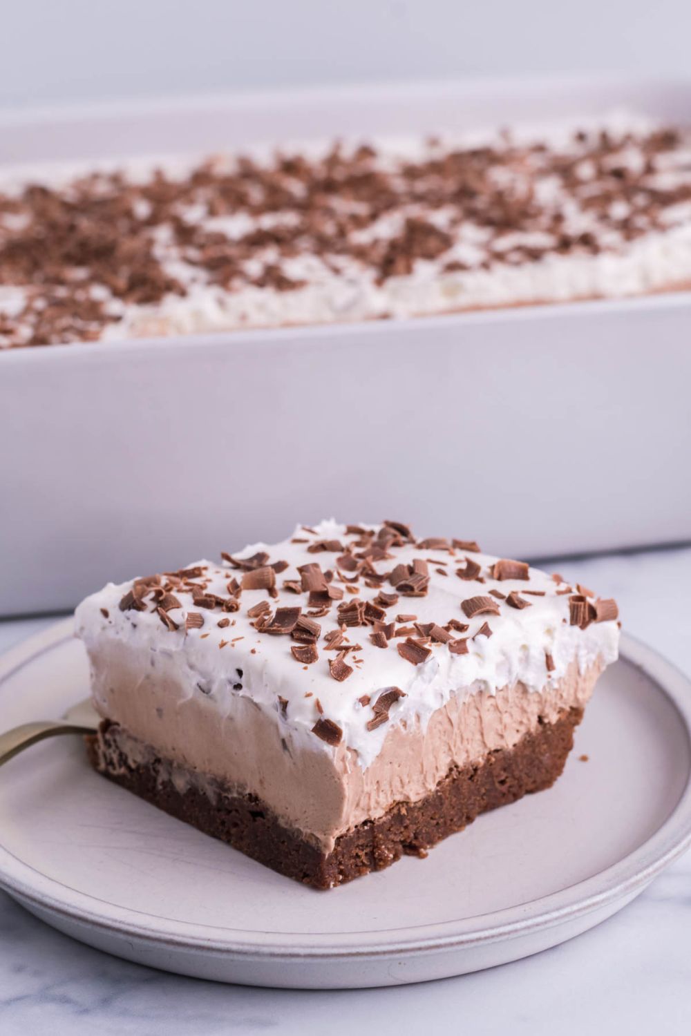 french silk cake sliced on plate with pan behind it
