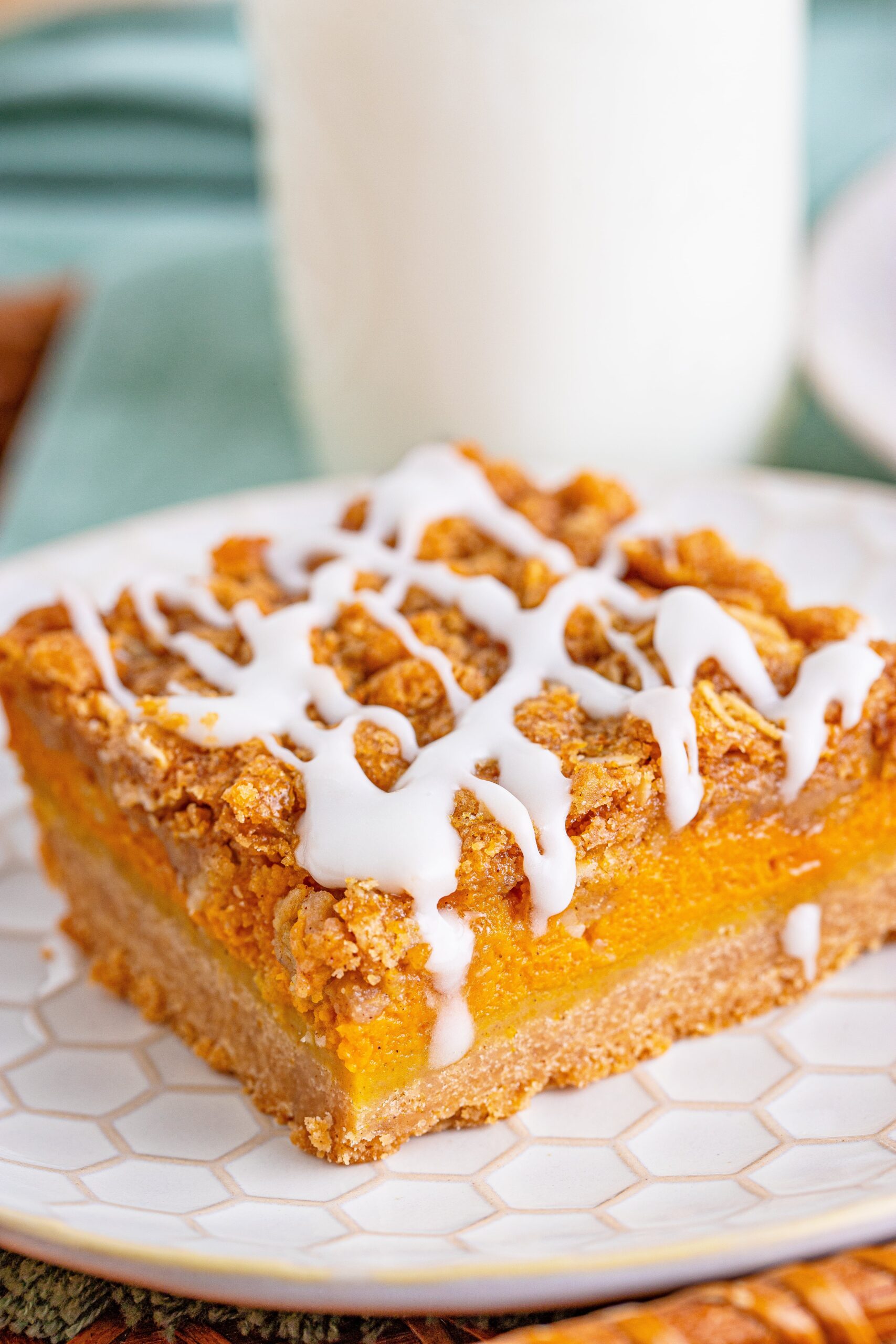 side view of pumpkin streusel bar on plate with milk