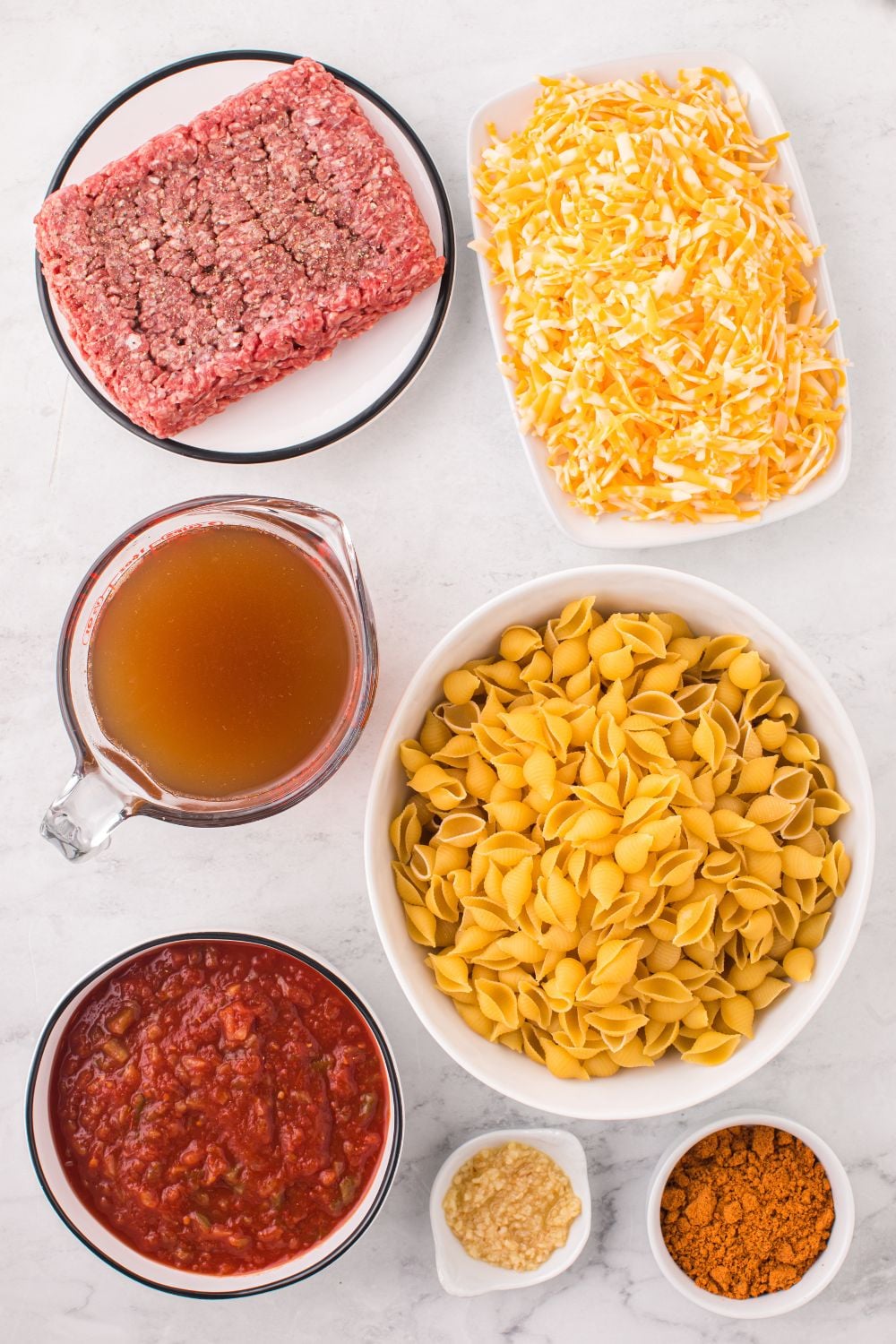 ground beef, pasta, and more in bowls on counter