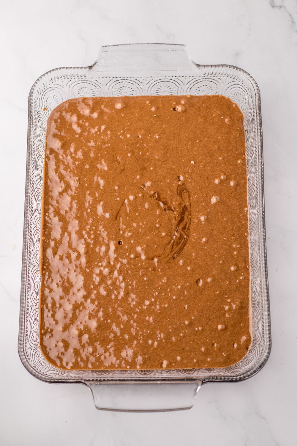 chocolate cake batter in a 9x13 baking dish on table