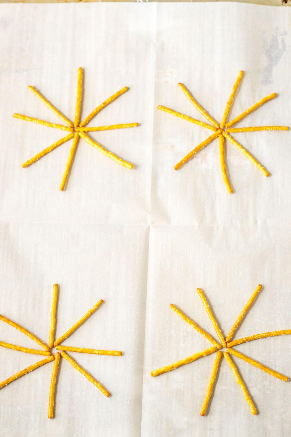 pretzels spread out on parchment paper lined baking sheet