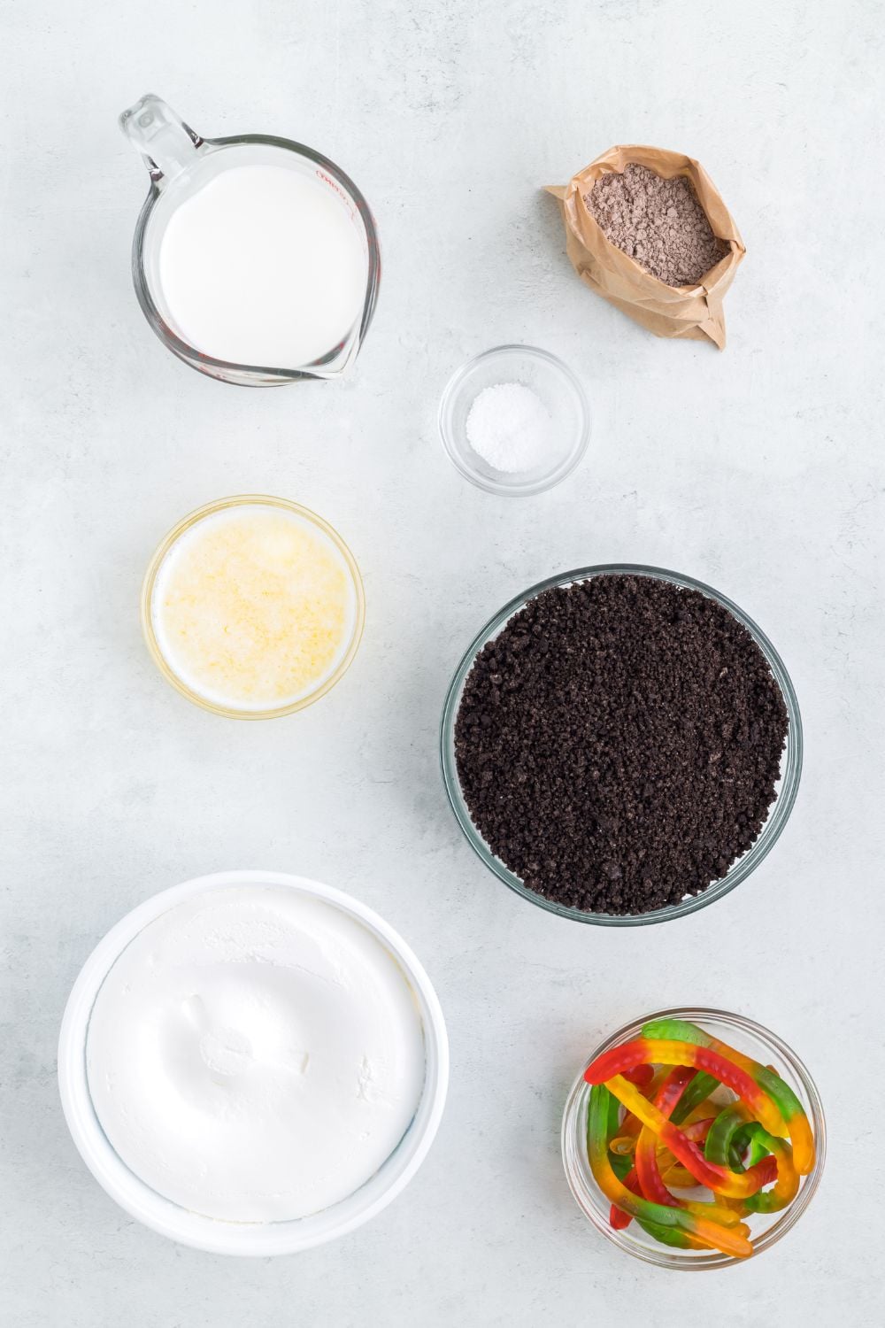 ingredients for Oreo dirt cake in glass bowls on table