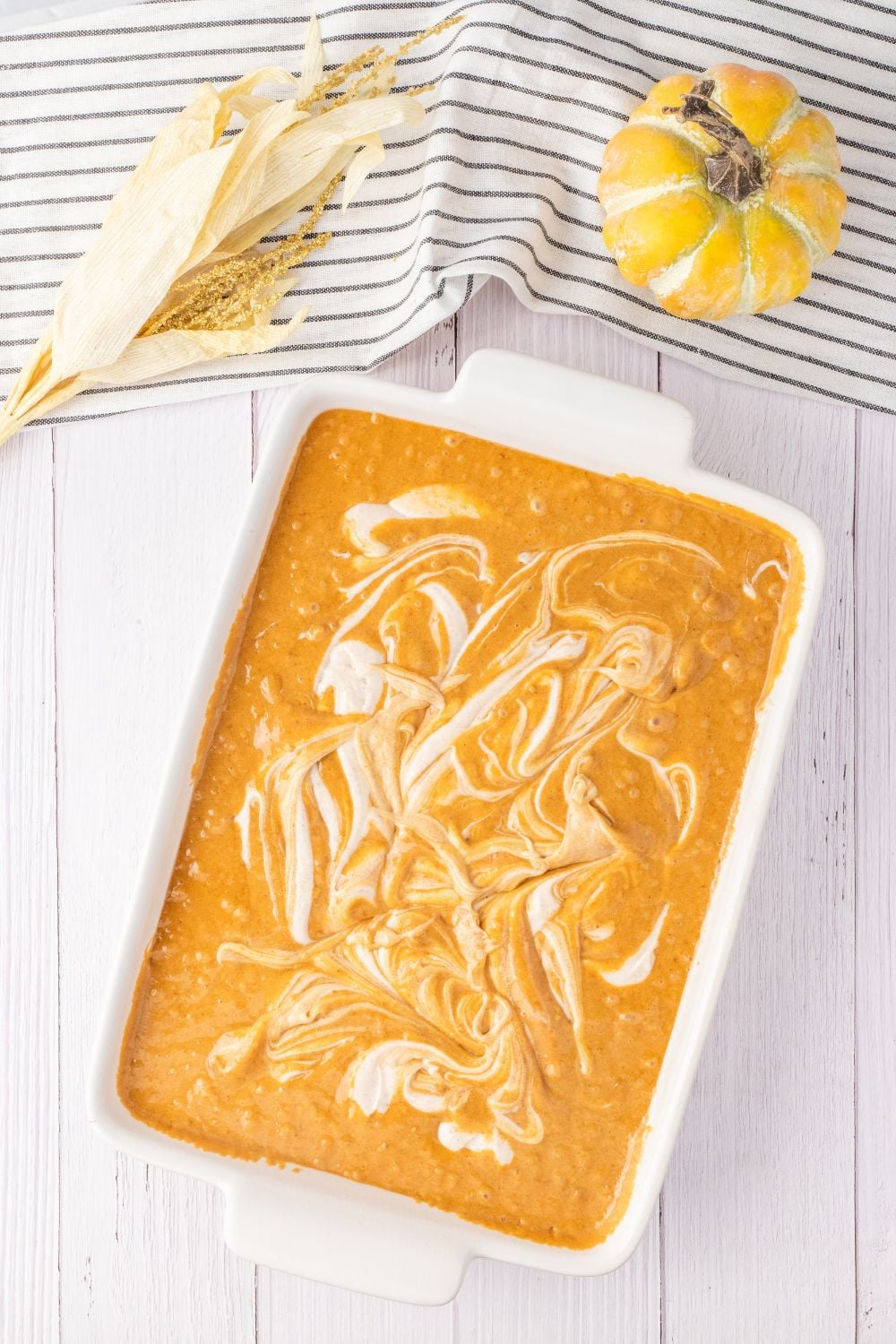 cream cheese batter swirled in pan of pumpkin cake batter