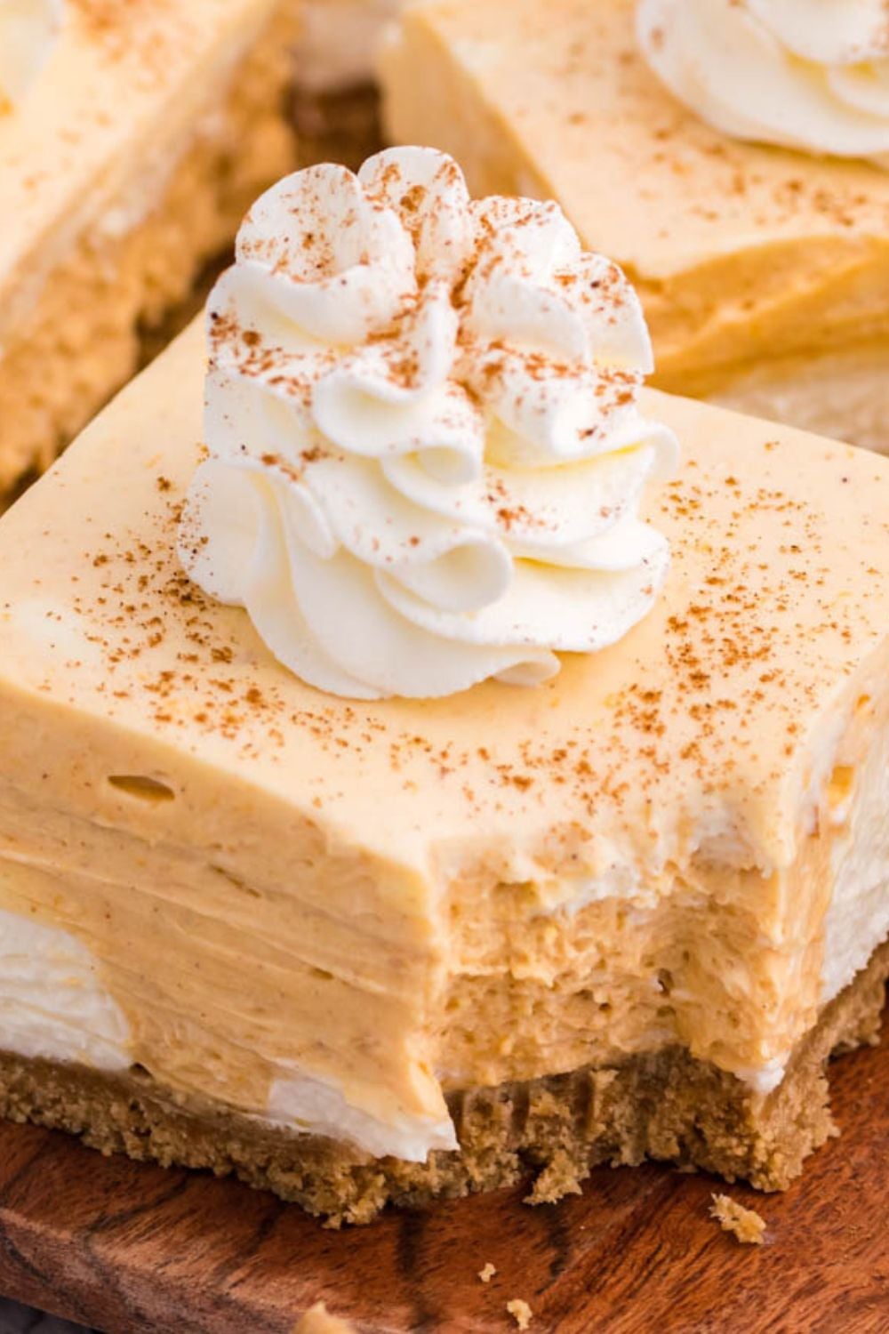 no bake pumpkin pie cheesecake bar with bite taken out sitting on plate