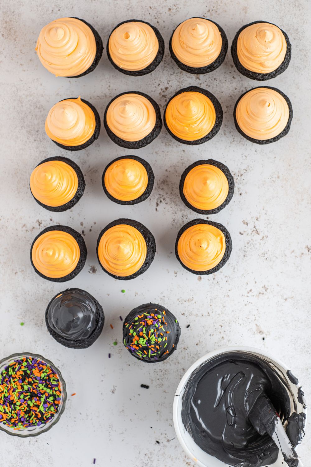 orange marshmallow frosted cupcakes on counter