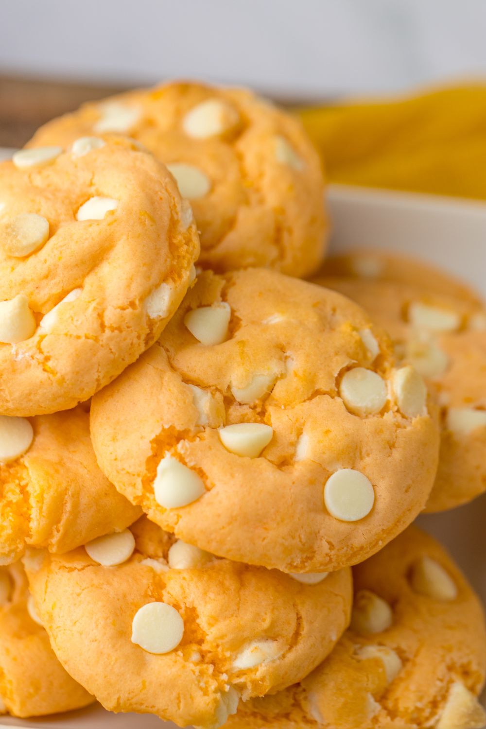 orange zest cookies stacked on top of each other on tray