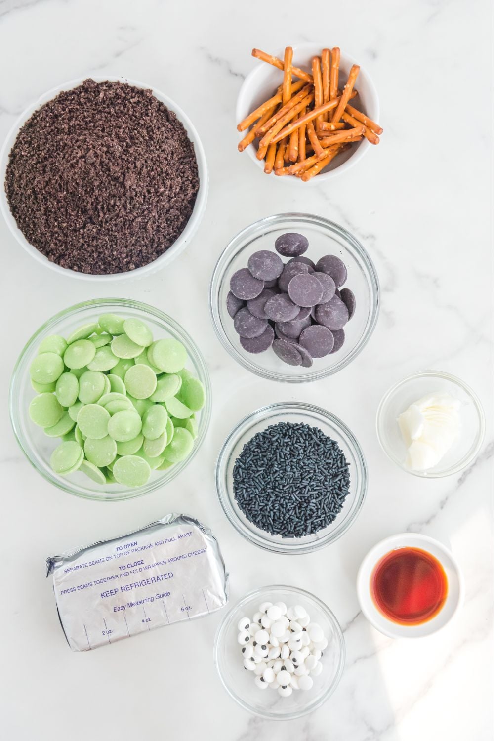 Frankenstein Oreo Balls ingredients on glass containers on a marble counter