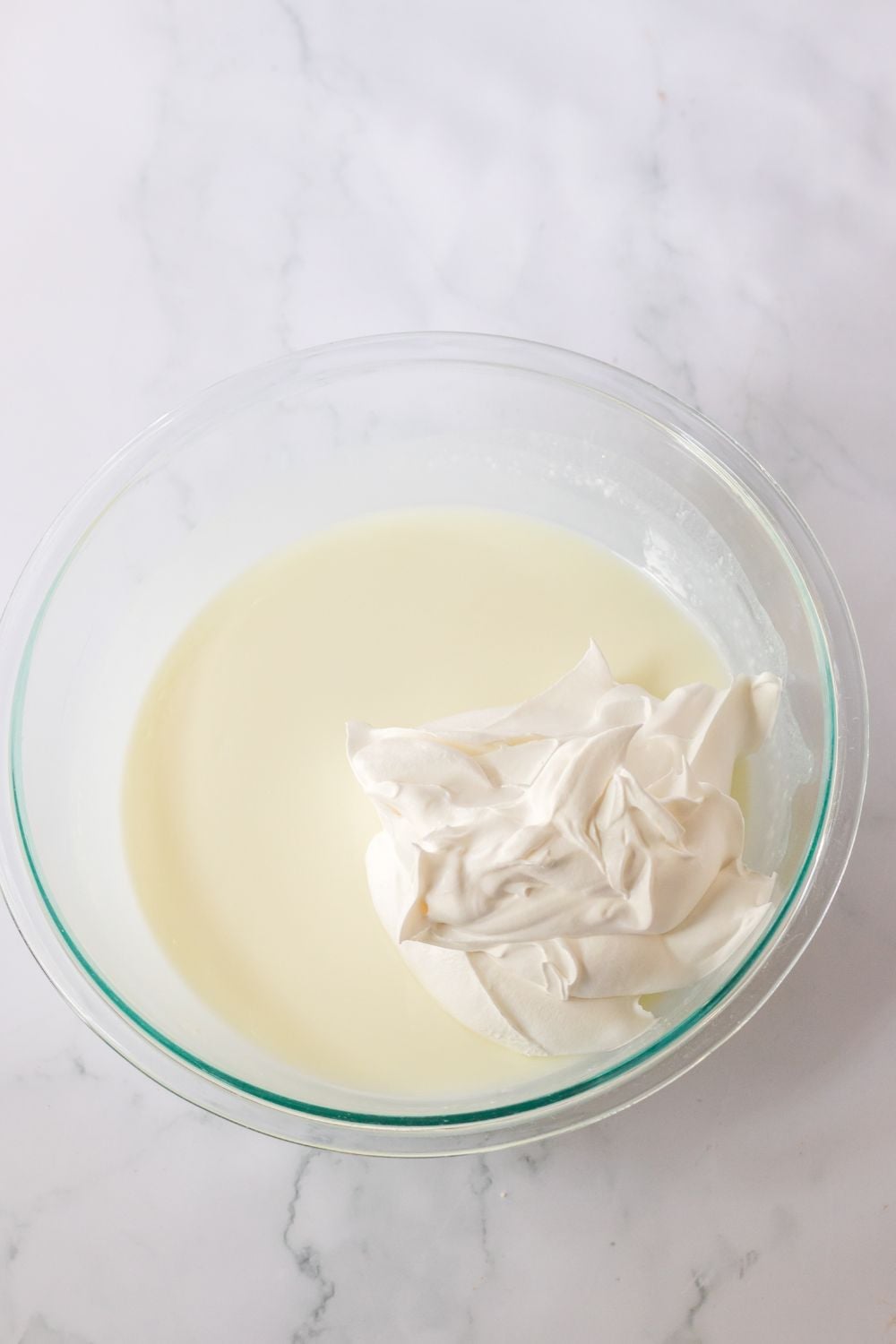 jello and whipped cream in a glass bowl