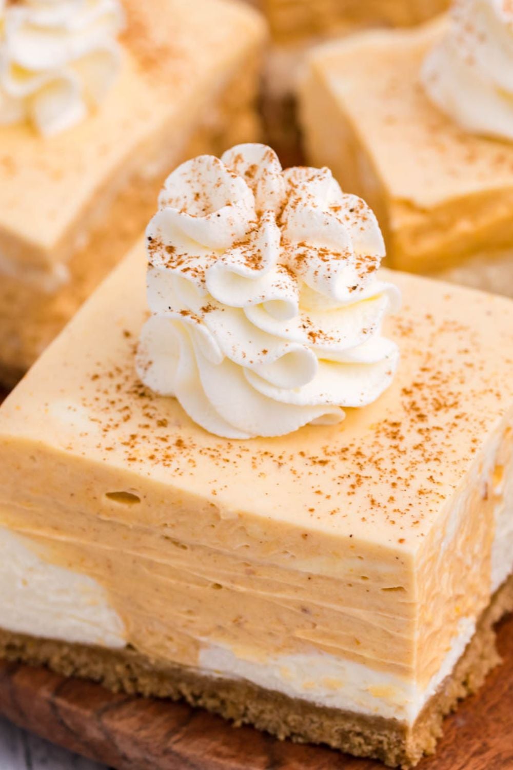 pumpkin pie cheesecake bars on table, close up view