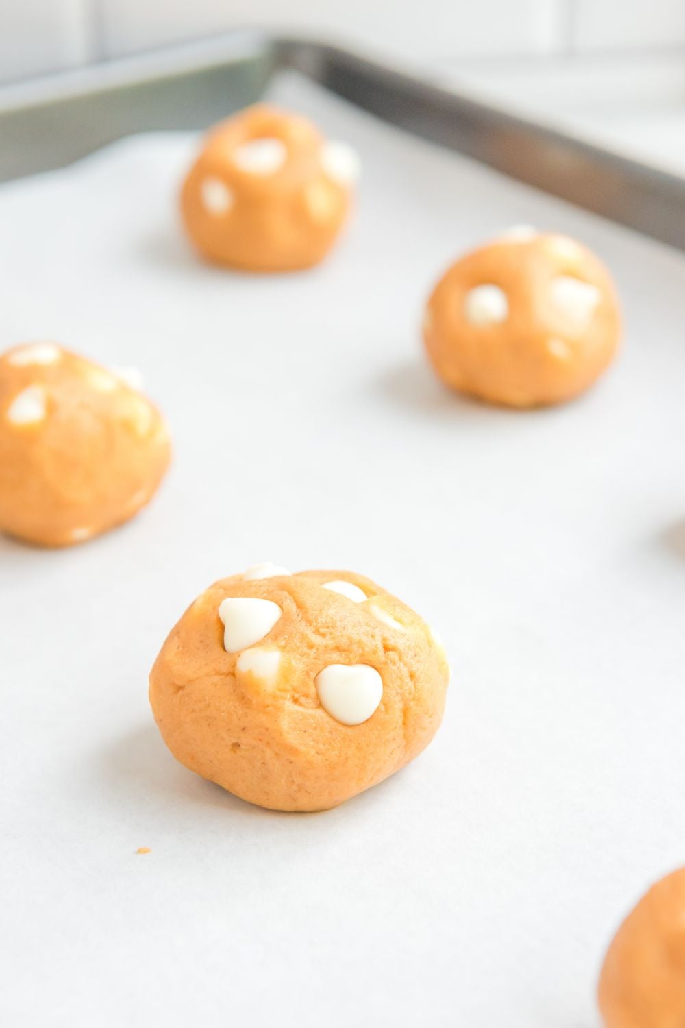 pumpkin cookie dough balls on cookie sheet